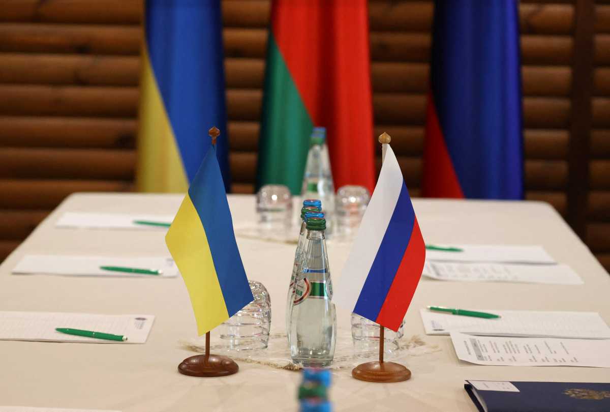 Ukrainian and Russian flags are seen on a table before the talks between officials of the two countries in the Brest region, Belarus March 3, 2022. Maxim Guchek