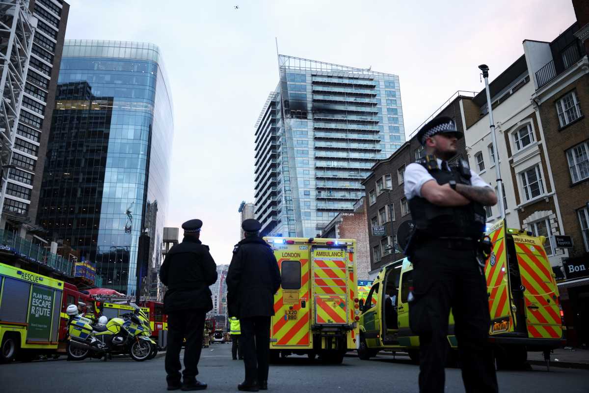 Police officers work at a fire site in East London, Britain, March 7, 2022. REUTERS
