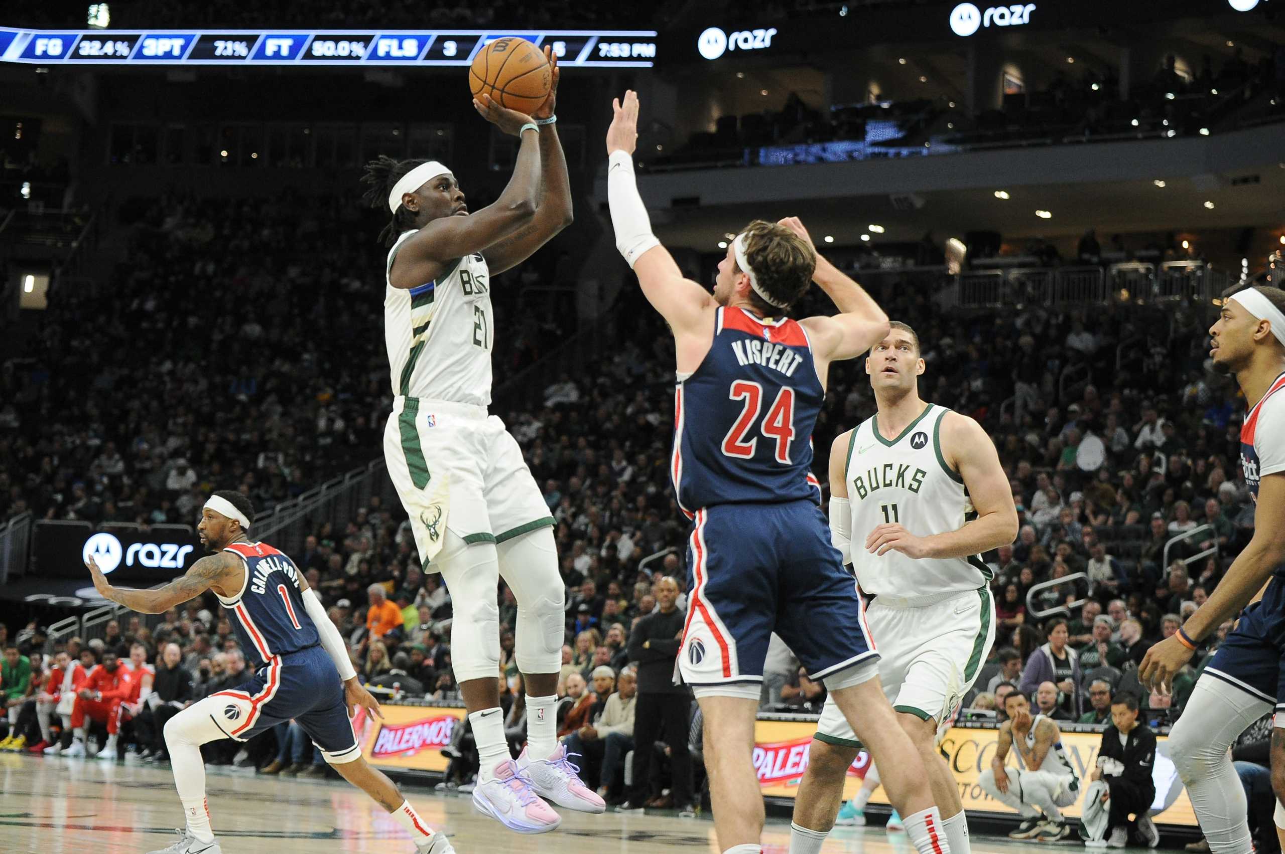 Mar 24, 2022; Milwaukee, Wisconsin, USA;  Milwaukee Bucks guard Jrue Holiday (21) shoots against Washington Wizards forward Corey Kispert (24) in the first half at Fiserv Forum. Mandatory Credit: Michael McLoone-USA TODAY Sports