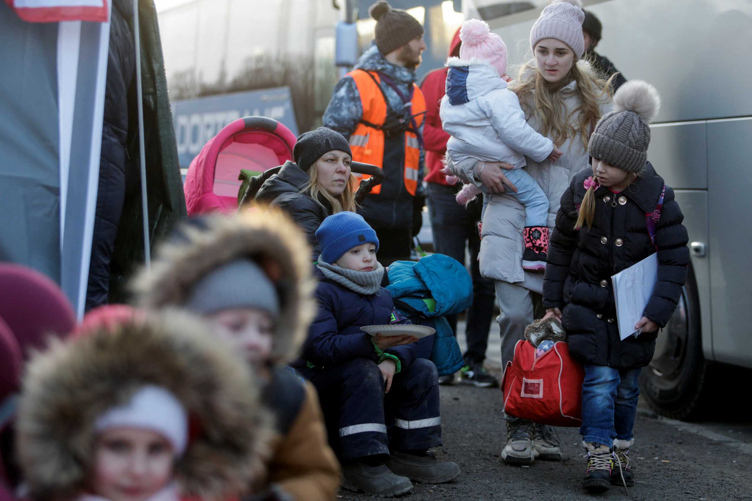 A person carrying a child walks as refugees from Ukraine cross the Ukrainian-Slovakian border following Russia's invasion of Ukraine, in Vysne Nemecke, Slovakia, March 3, 2022. REUTERS