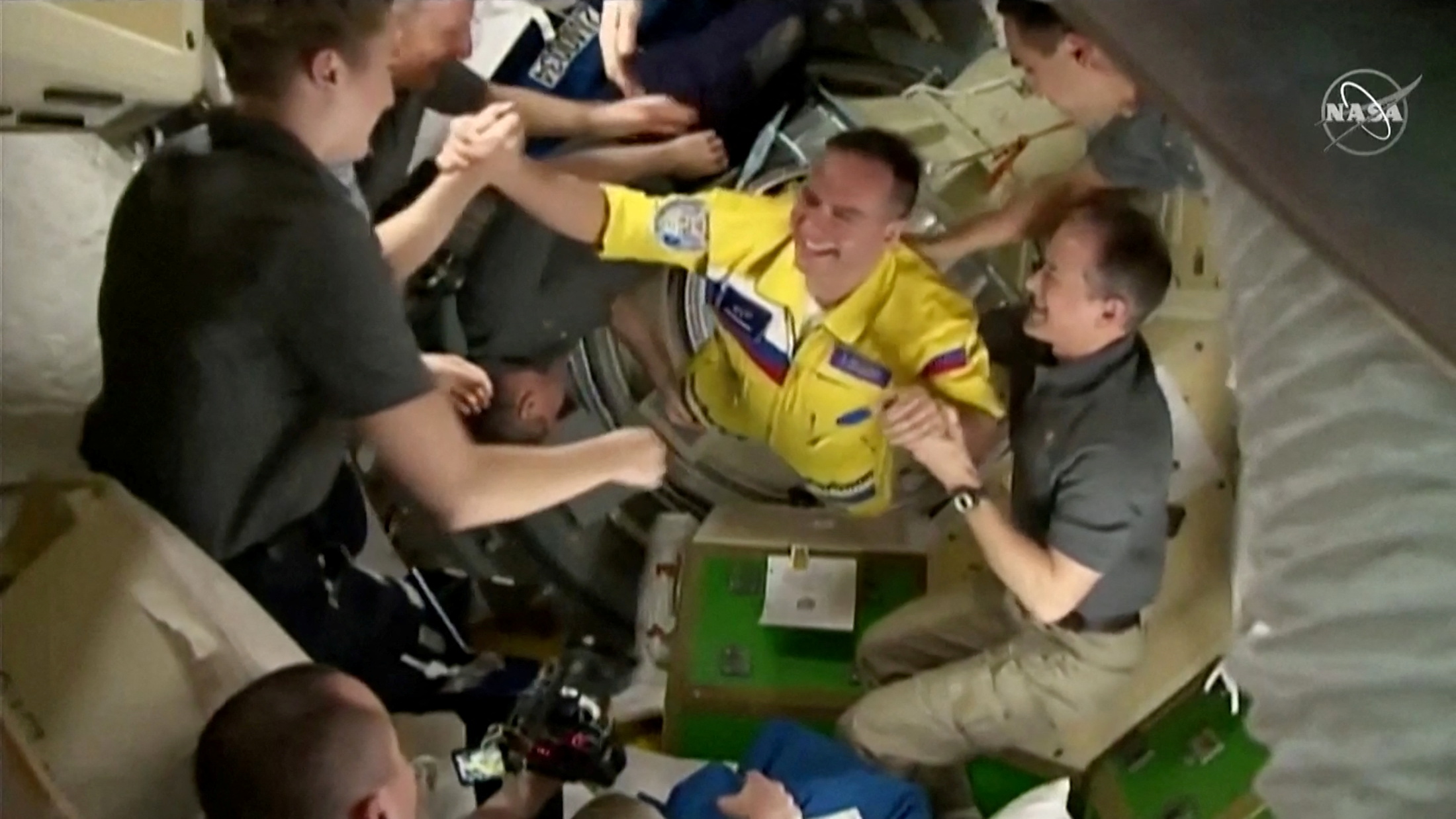 Russian cosmonauts arrive wearing yellow and blue flight suits at the International Space Station after docking their Soyuz capsule March 18, 2022 i a still image from video. Video taken March 18, 2022.  NASA TV