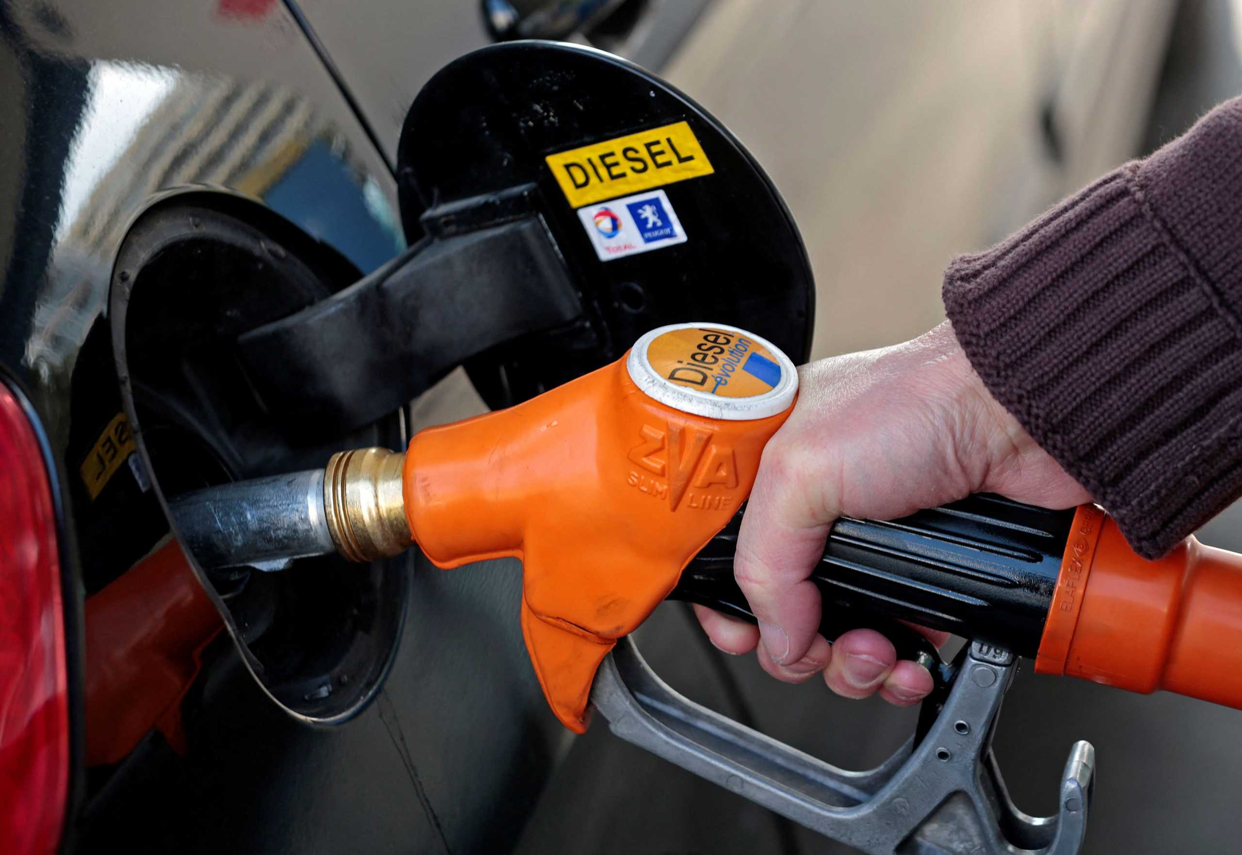 FILE PHOTO: A customer fills-up his car with diesel at a gas station in Nice March 4, 2013. France is considering creating a car scrappage scheme for owners of older diesel vehicles as the country reviews a pro-diesel policy criticised as costly and contributing to health risks.   REUTERS