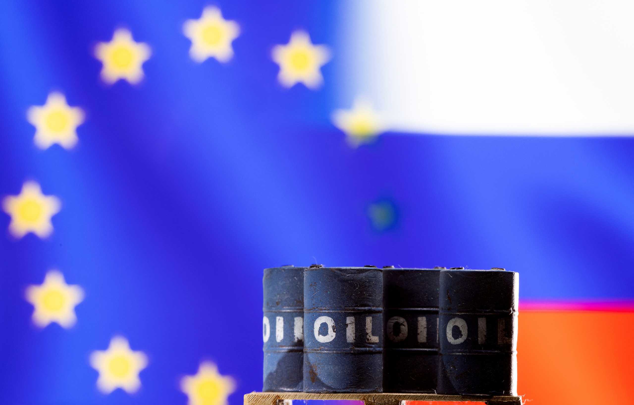 Models of oil barrels are seen in front of displayed U.S. and Russia flag colours in this illustration taken March 8, 2022. REUTERS