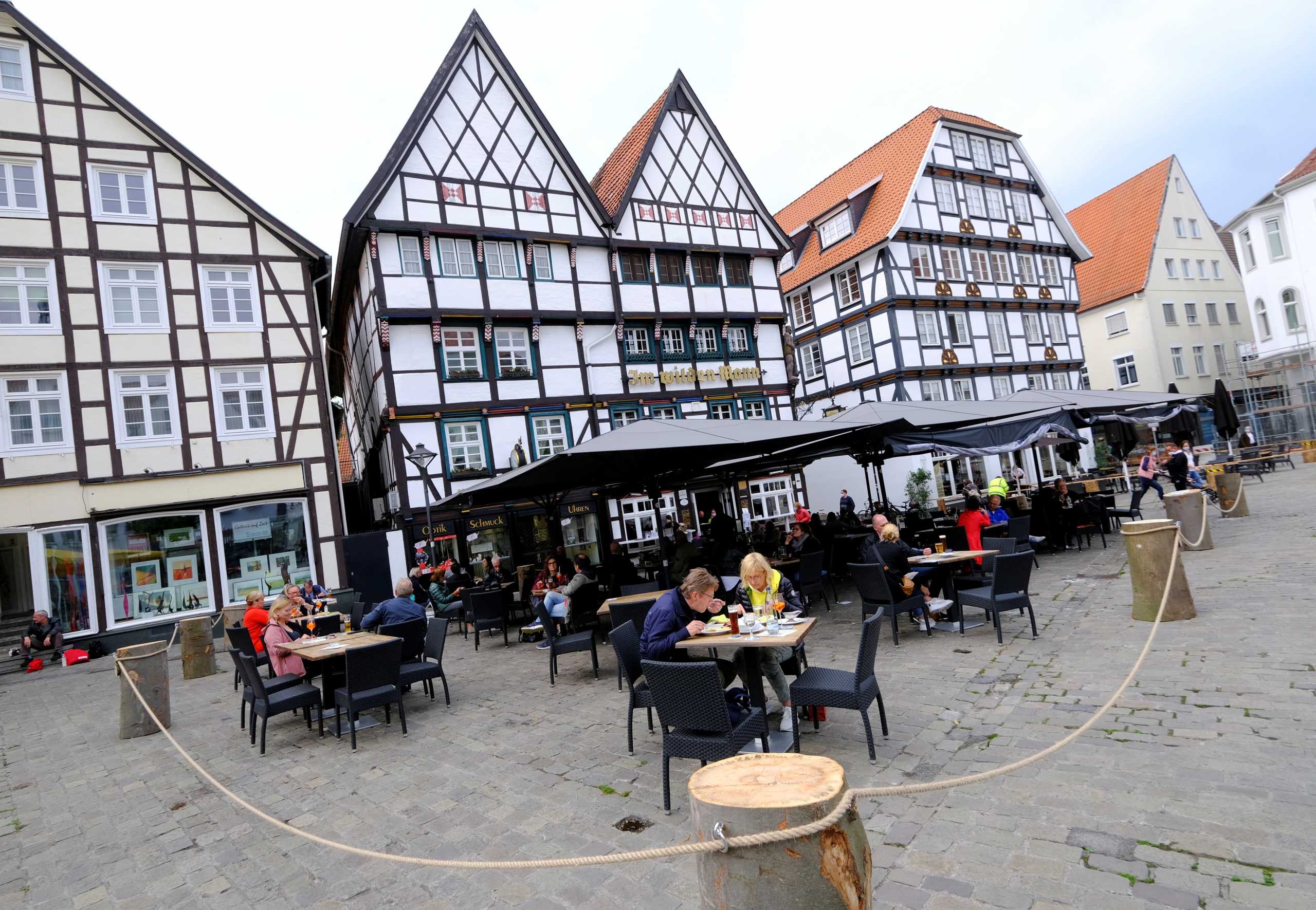 FILE PHOTO: People eat outdoors in a cordoned-off area of a restaurant on the historic main market square of Soest, Germany, May 12, 2021.    REUTERS