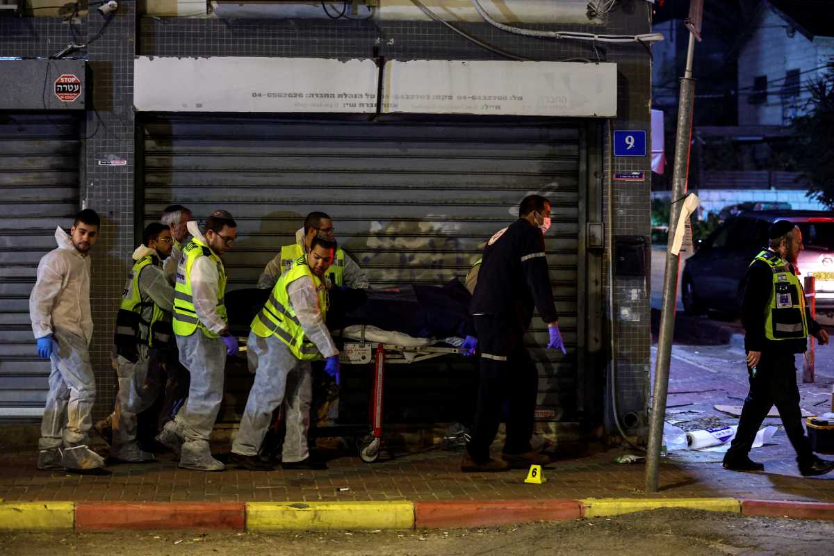Israeli medical personnel and rescue workers evacuate a dead body from the scene of an attack in which people were killed by gunmen on a main street in Hadera, Israel, March 27, 2022. REUTERS
