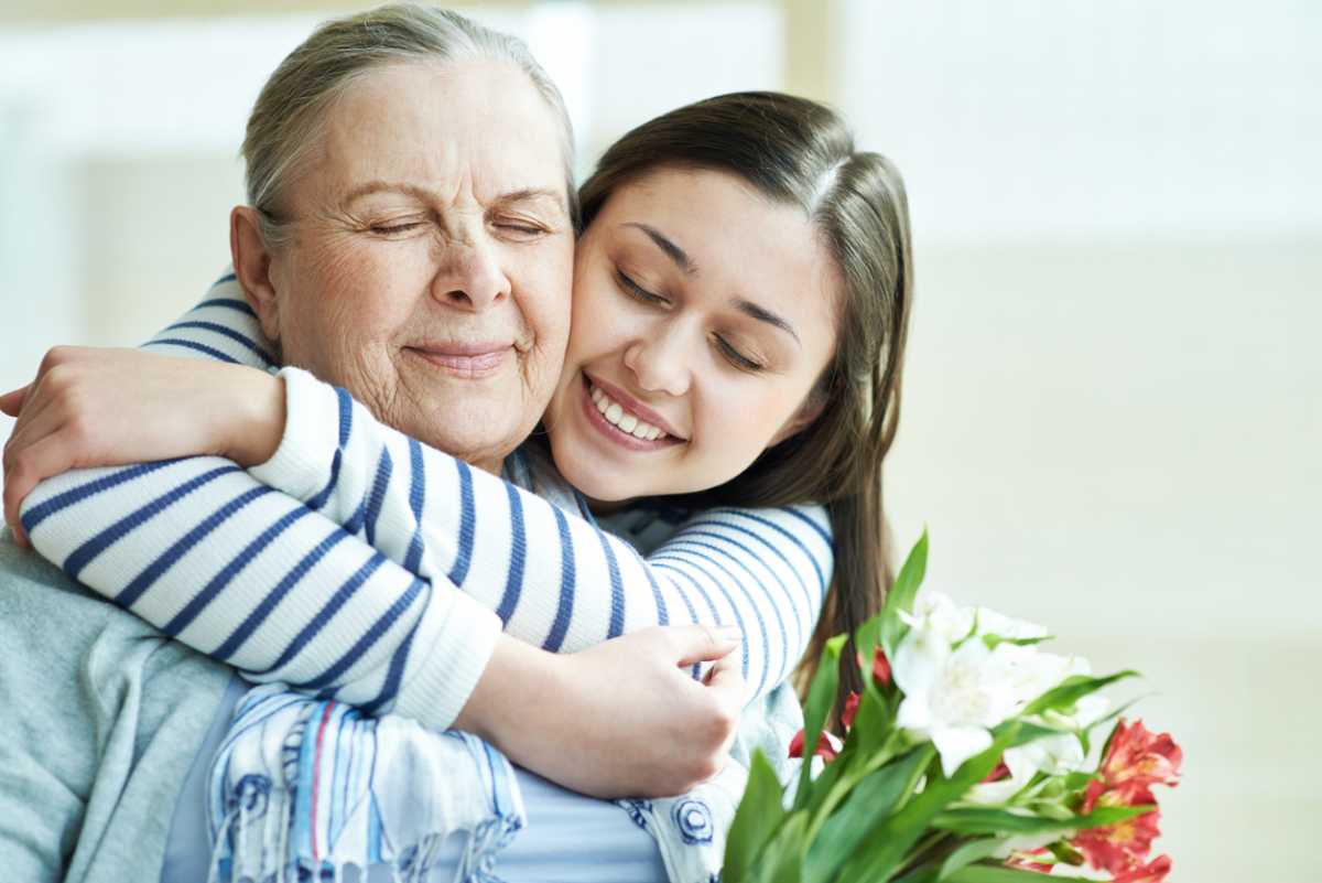 Young woman embracing warmly her grandmother on Mother's Day