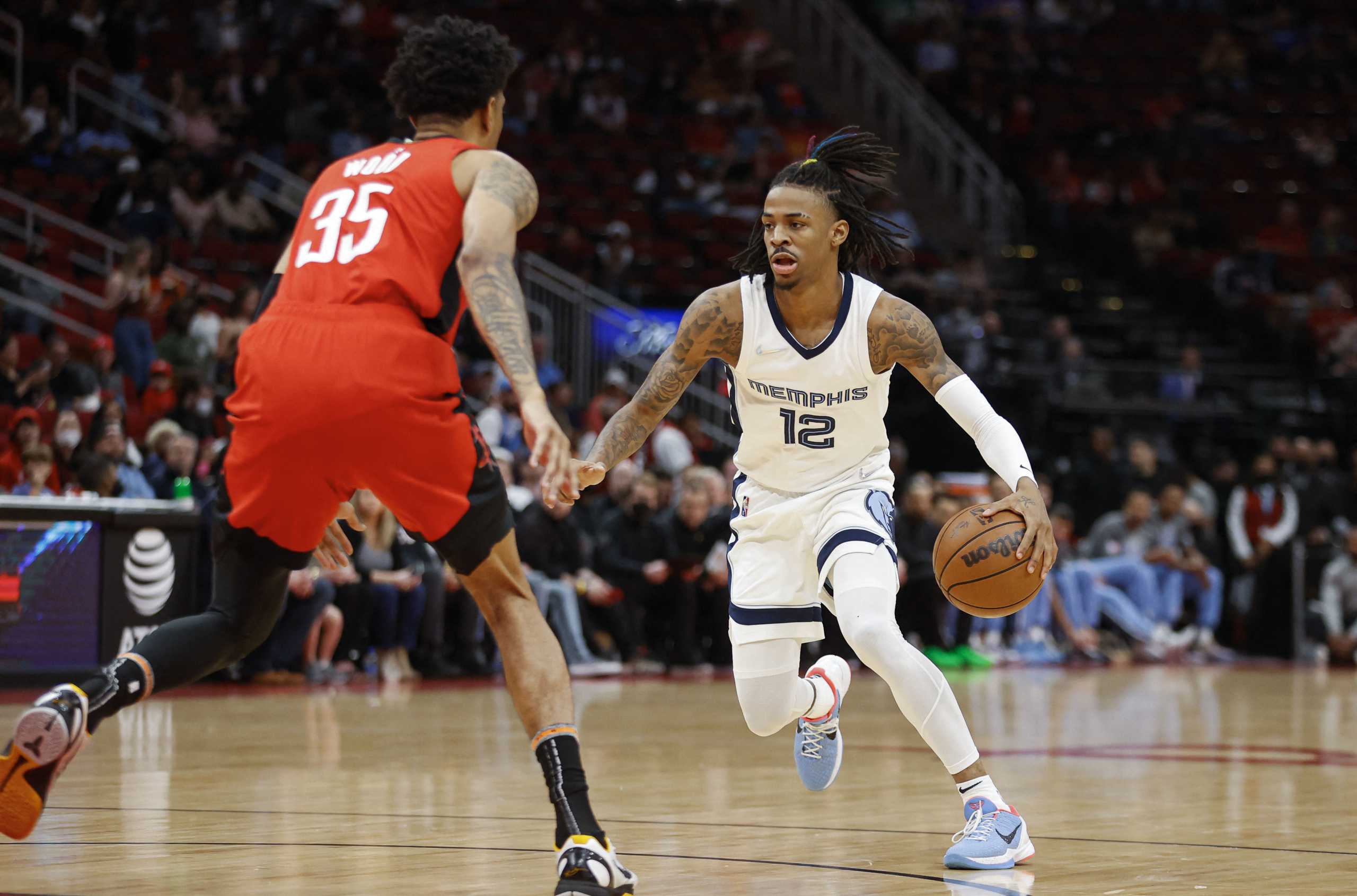 Mar 6, 2022; Houston, Texas, USA; Memphis Grizzlies guard Ja Morant (12) dribbles the ball as Houston Rockets center Christian Wood (35) defends during the first quarter at Toyota Center. Mandatory Credit: Troy Taormina-USA TODAY Sports
