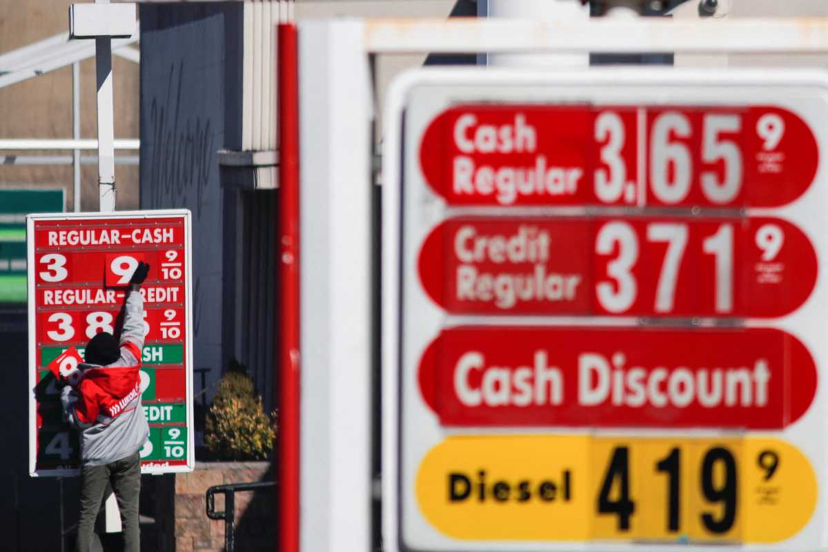 A worker changes the numbers of a price at the Lukoil fuel station, after local officials voted to suspend the business license of local Lukoil gas stations following the Russian's invasion of Ukraine, in Newark, New Jersey, U.S., March 3, 2022. REUTERS