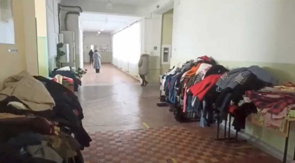 Clothes are seen on tables as Ukrainians evacuated from Mariupol walk at an accommodation center in Berdyansk, Ukraine March 18, 2022 in this screen grab taken from a handout video. Kirill Timoshenko