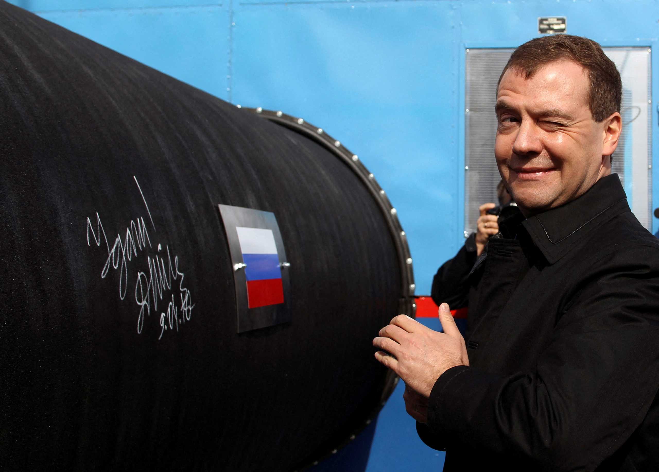 FILE PHOTO: Russian President Dmitry Medvedev gestures after writing 'Good Luck!' on a pipe of the Nord Stream pipeline near Russian town of Vyborg, April 9, 2010.  REUTERS
