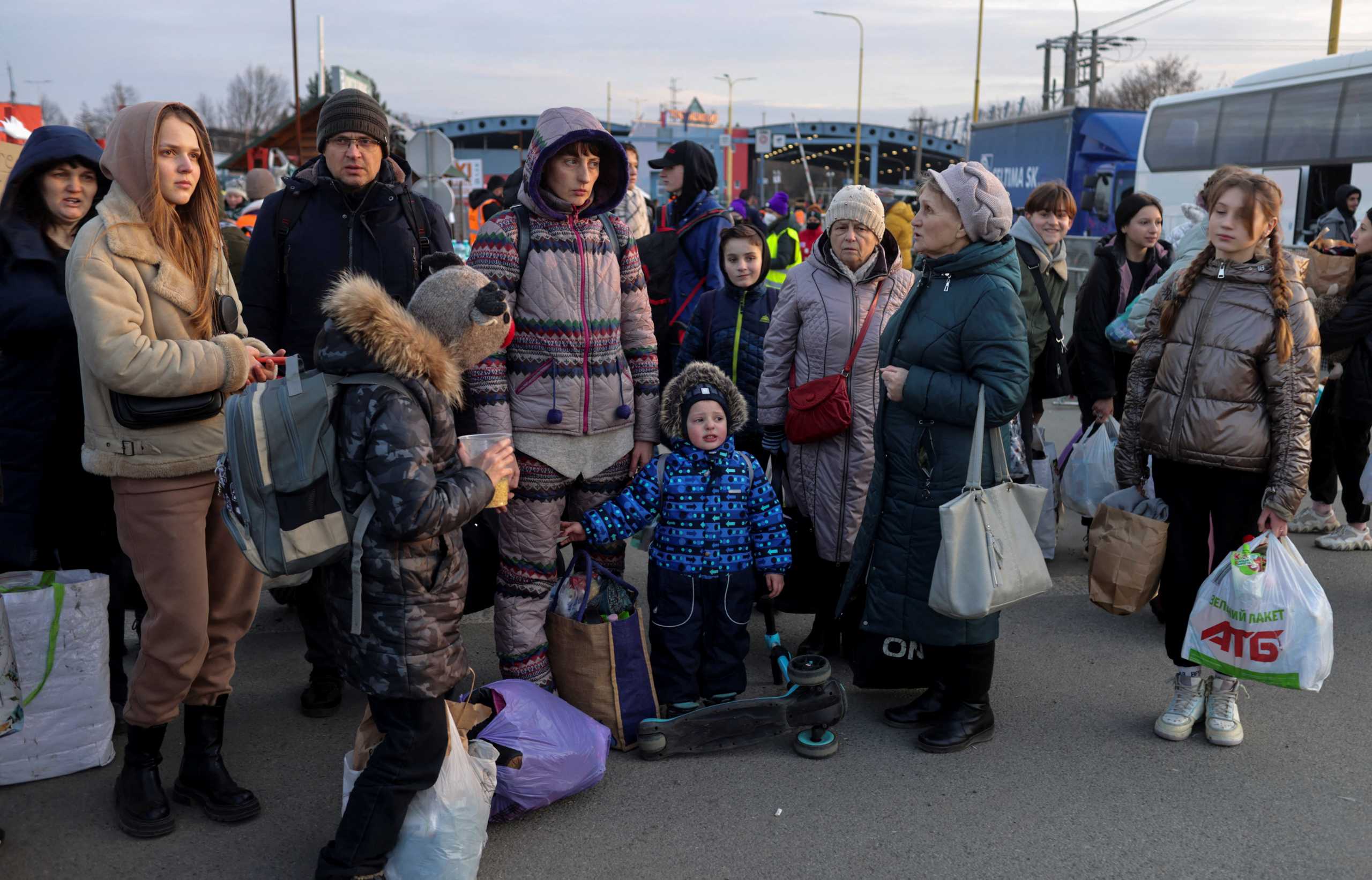 People stand as refugees from Ukraine cross the Ukrainian-Slovakian border following Russia's invasion of Ukraine, in Vysne Nemecke, Slovakia, March 3, 2022. REUTERS