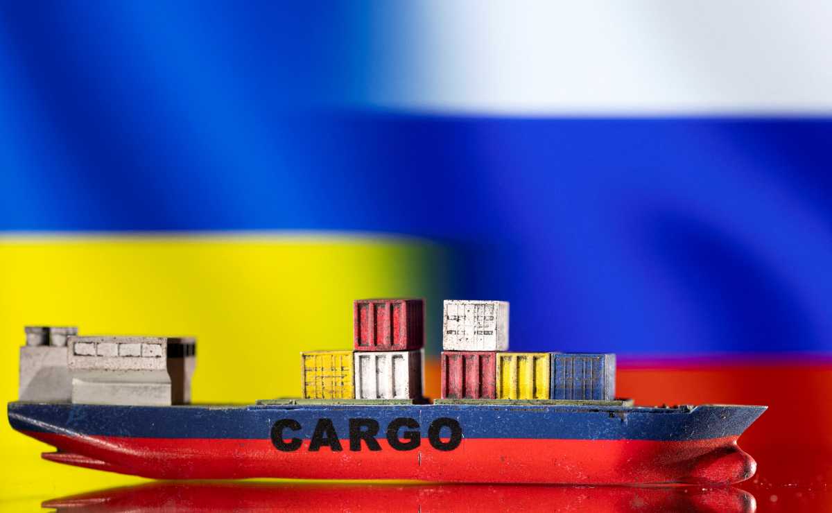 FILE PHOTO: A cargo ship boat model is pictured in front of Ukraine's and Russian's flags in this illustration taken March 3, 2022. REUTERS