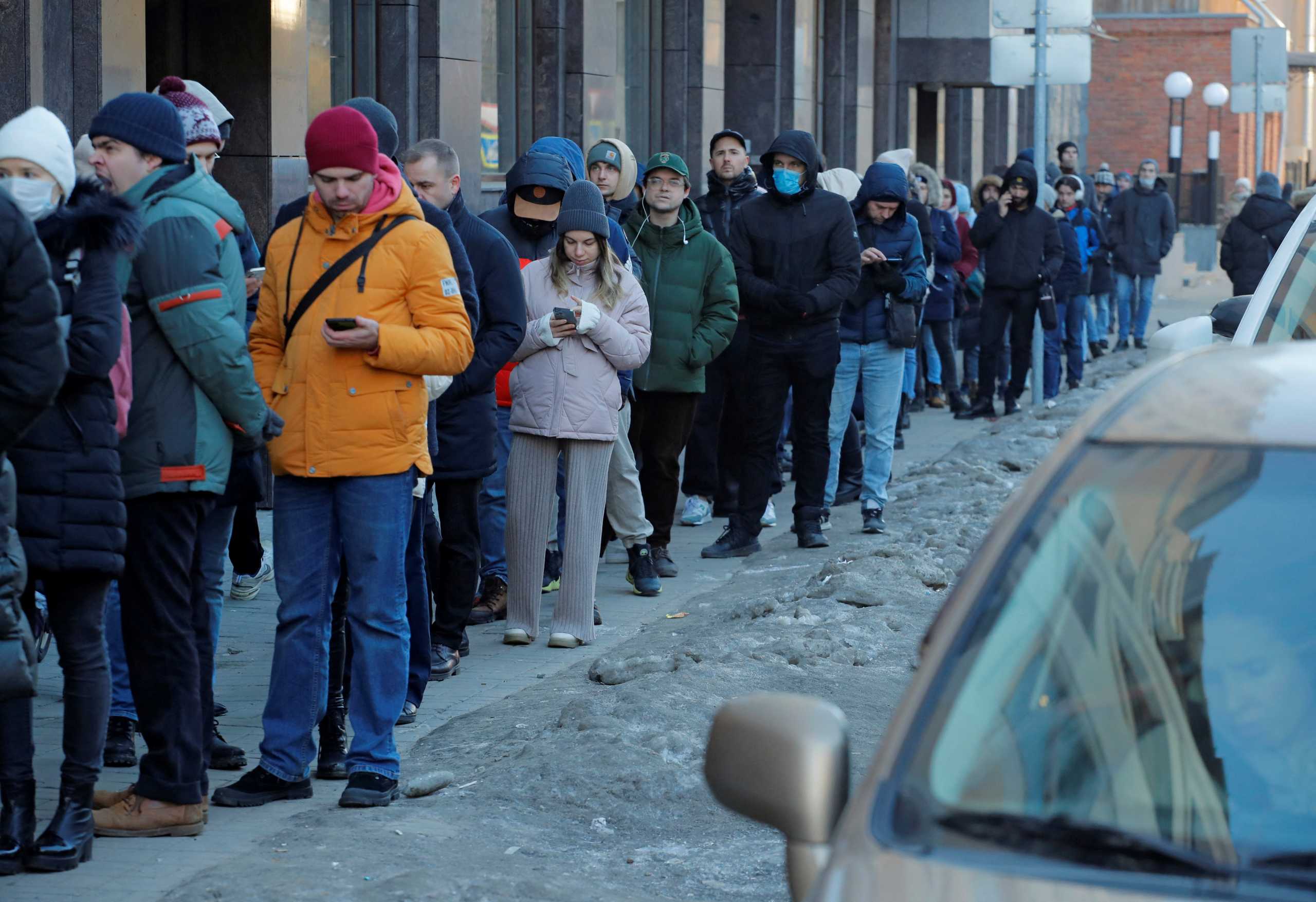 People stand in line to use an ATM money machine in Saint Petersburg, Russia February 27, 2022. REUTERS