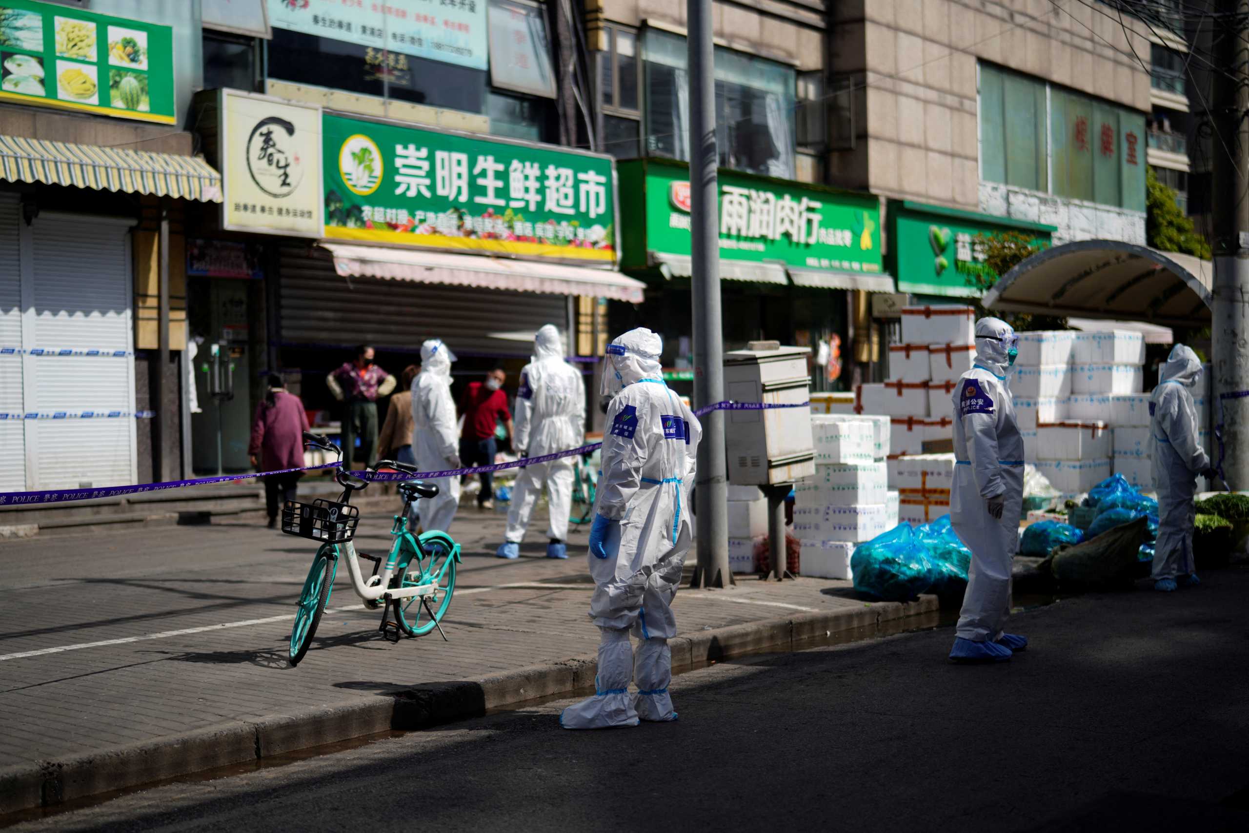 Police and security members in protective suits stand outside cordoned off food stores following the coronavirus disease (COVID-19) outbreak in Shanghai, China March 29, 2022. REUTERS