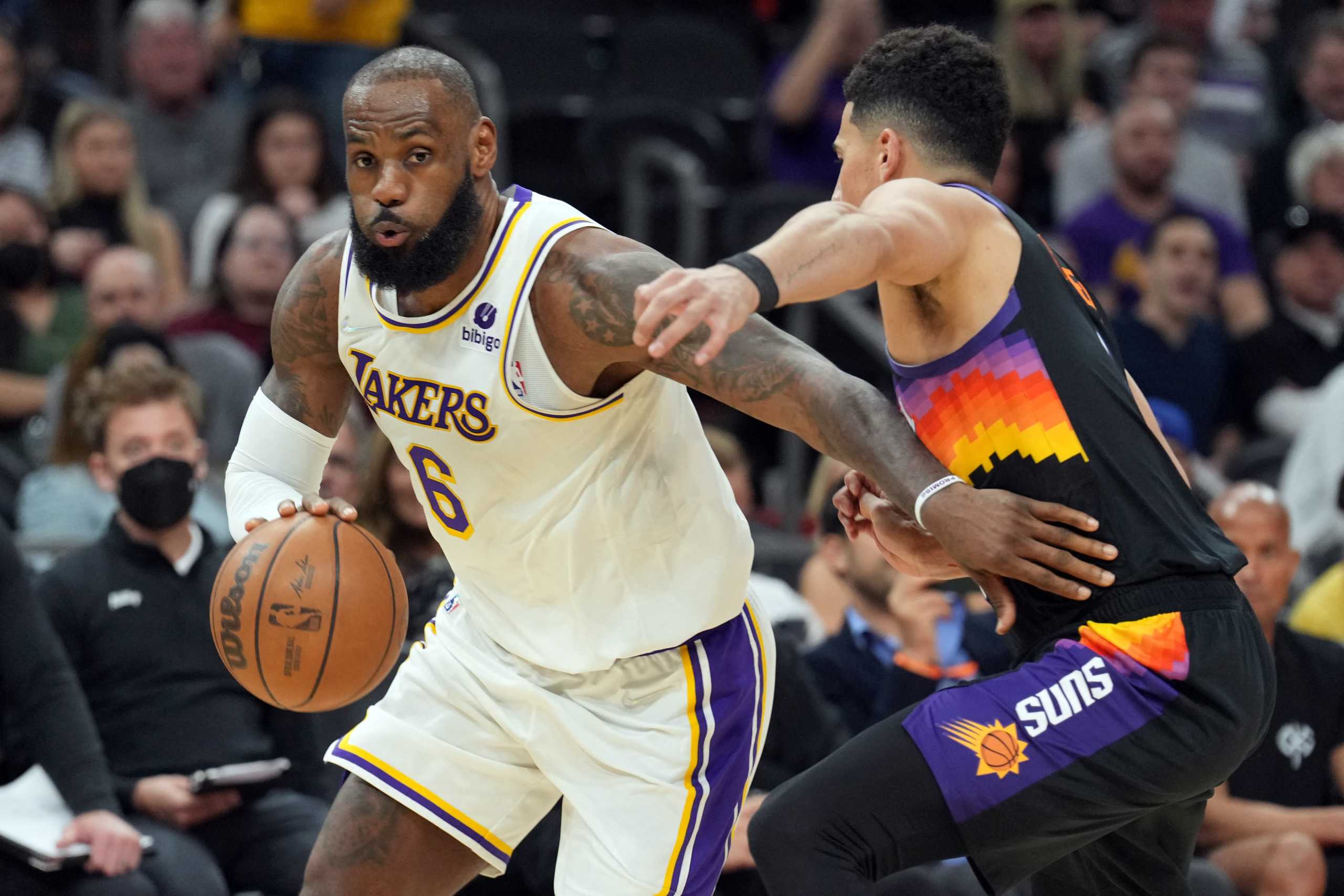 Mar 13, 2022; Phoenix, Arizona, USA; Los Angeles Lakers forward LeBron James (6) dribbles against Phoenix Suns guard Devin Booker (1) during the second half at Footprint Center. Mandatory Credit: Joe Camporeale-USA TODAY Sports
