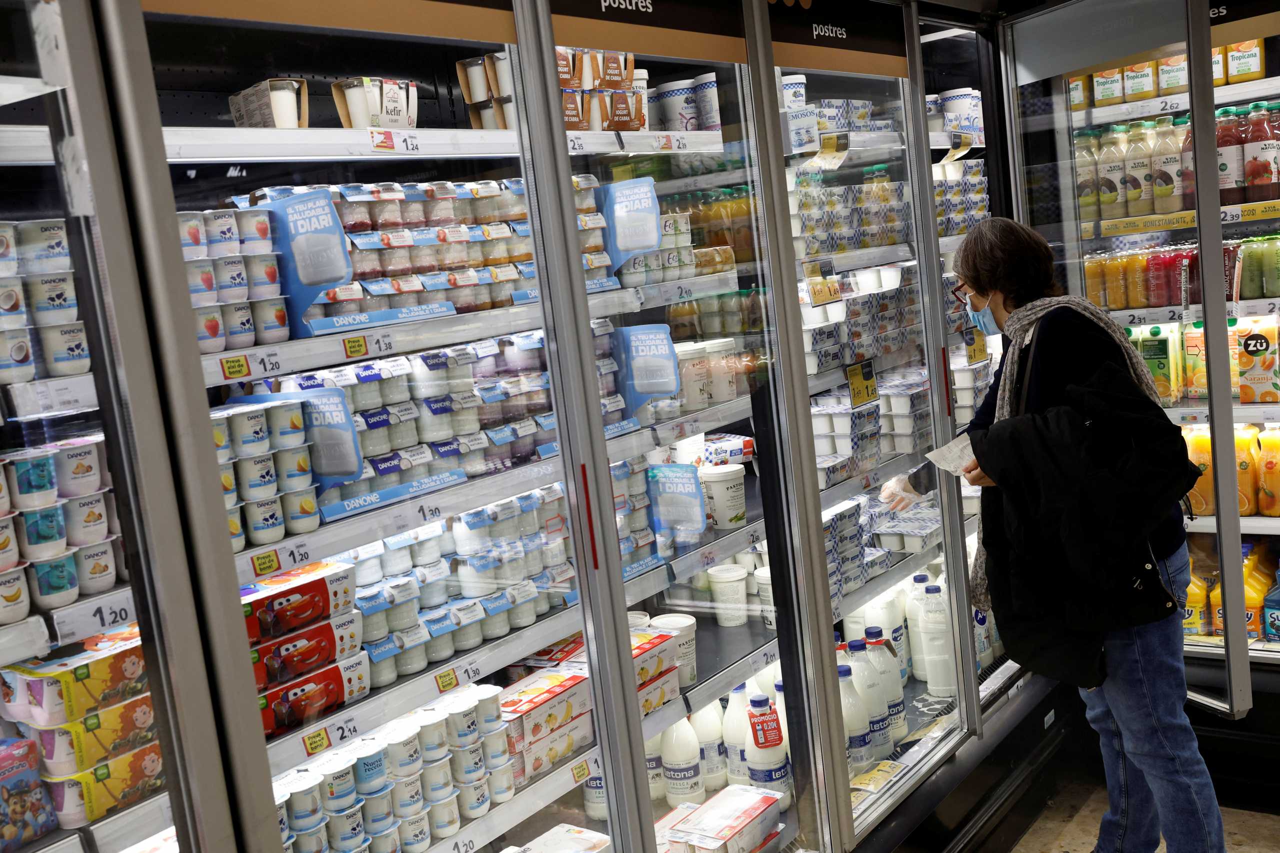 A woman takes some yogurts from a fridge in a Caprabo supermarket in Barcelona, Spain, March 21, 2022. REUTERS