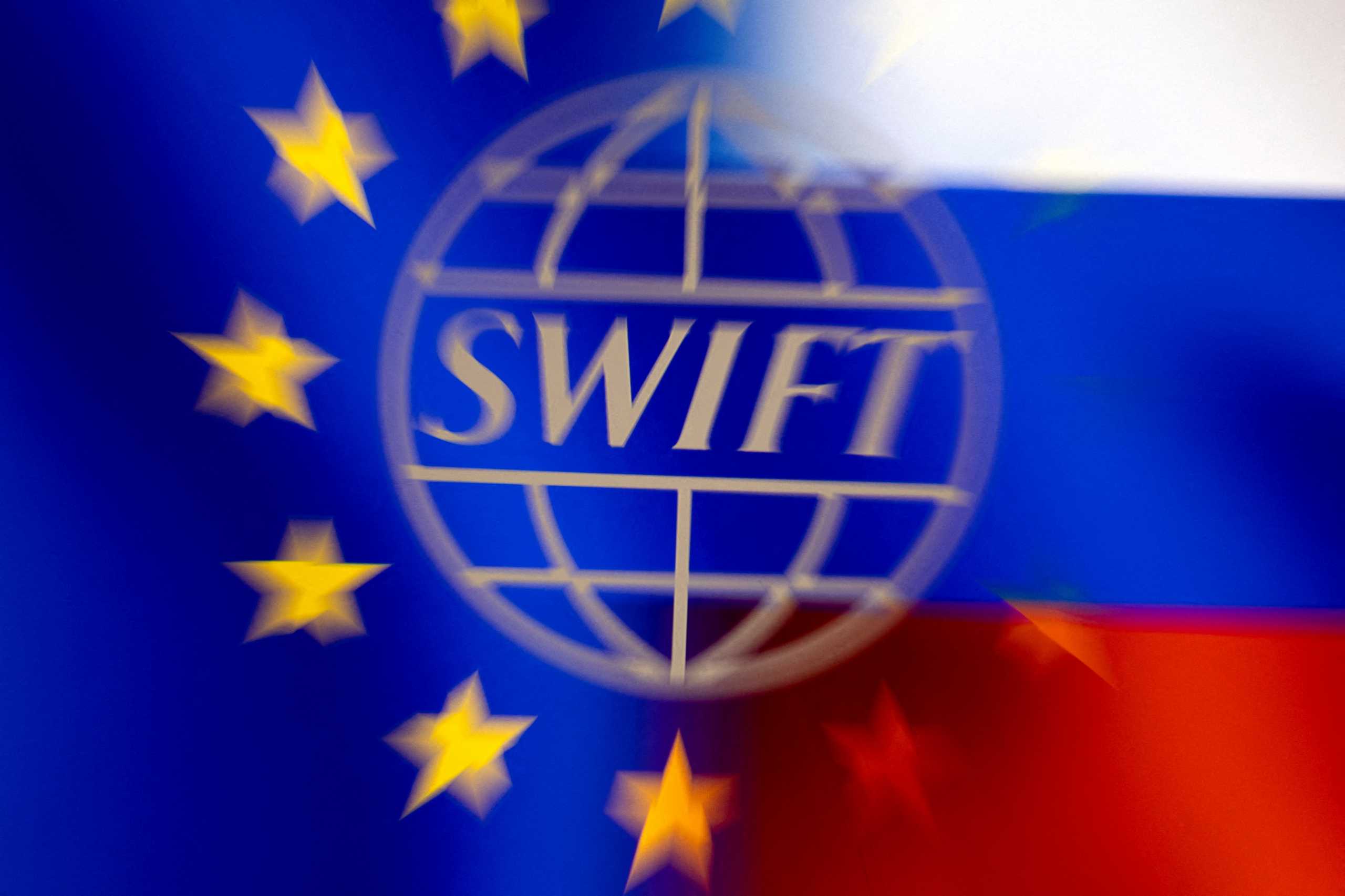 FILE PHOTO: Swift logo is pictured with EU and Russian flags in this illustration picture taken February 26, 2022. REUTERS
