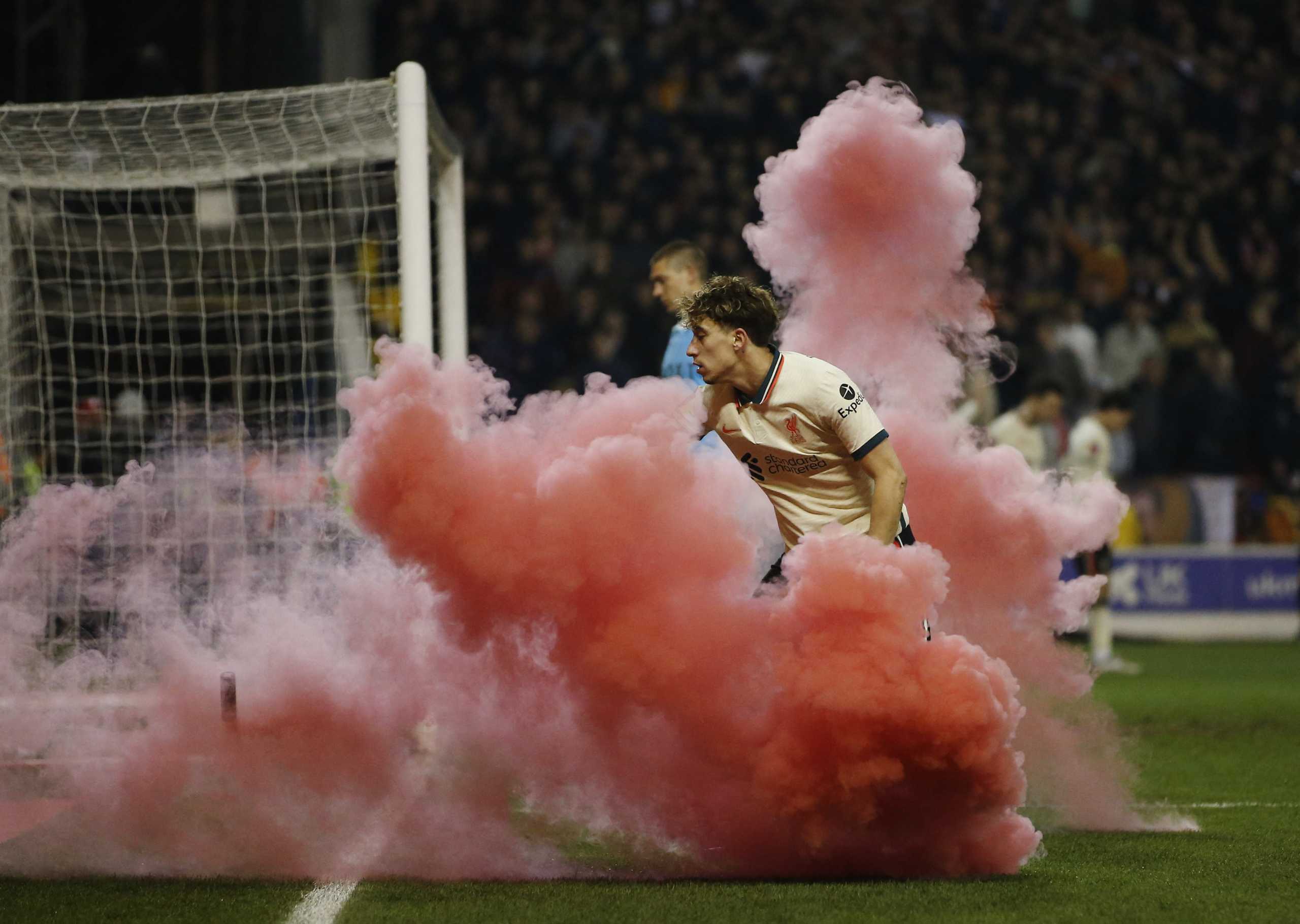 Soccer Football - FA Cup Quarter Final - Nottingham Forest v Liverpool - The City Ground, Nottingham, Britain - March 20, 2022 Liverpool's Kostas Tsimikas reacts after a flare is thrown onto the pitch REUTERS