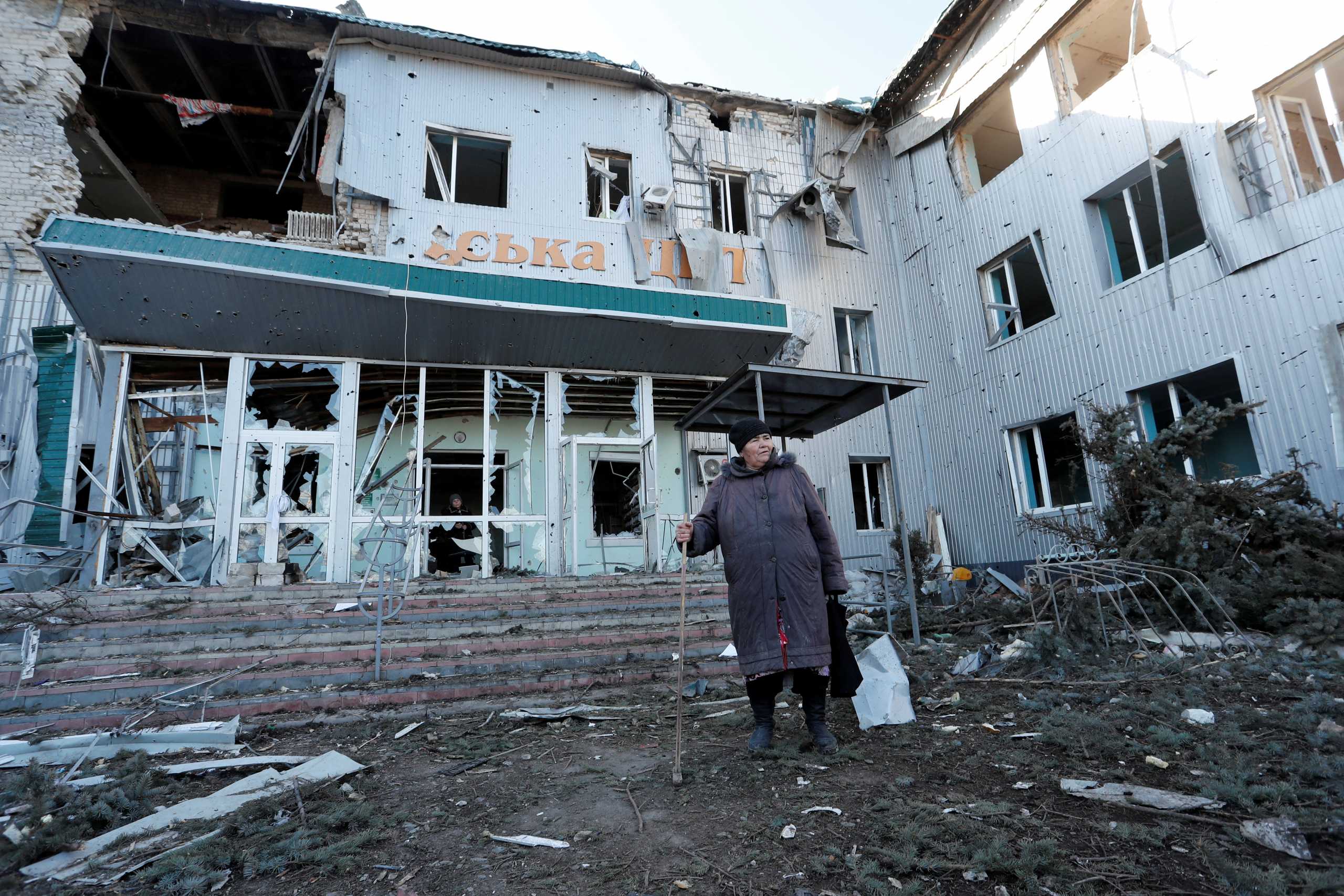 A woman stands outside a local hospital, which was destroyed during Ukraine-Russia conflict in the separatist-controlled town of Volnovakha in the Donetsk region, Ukraine March 12, 2022. REUTERS