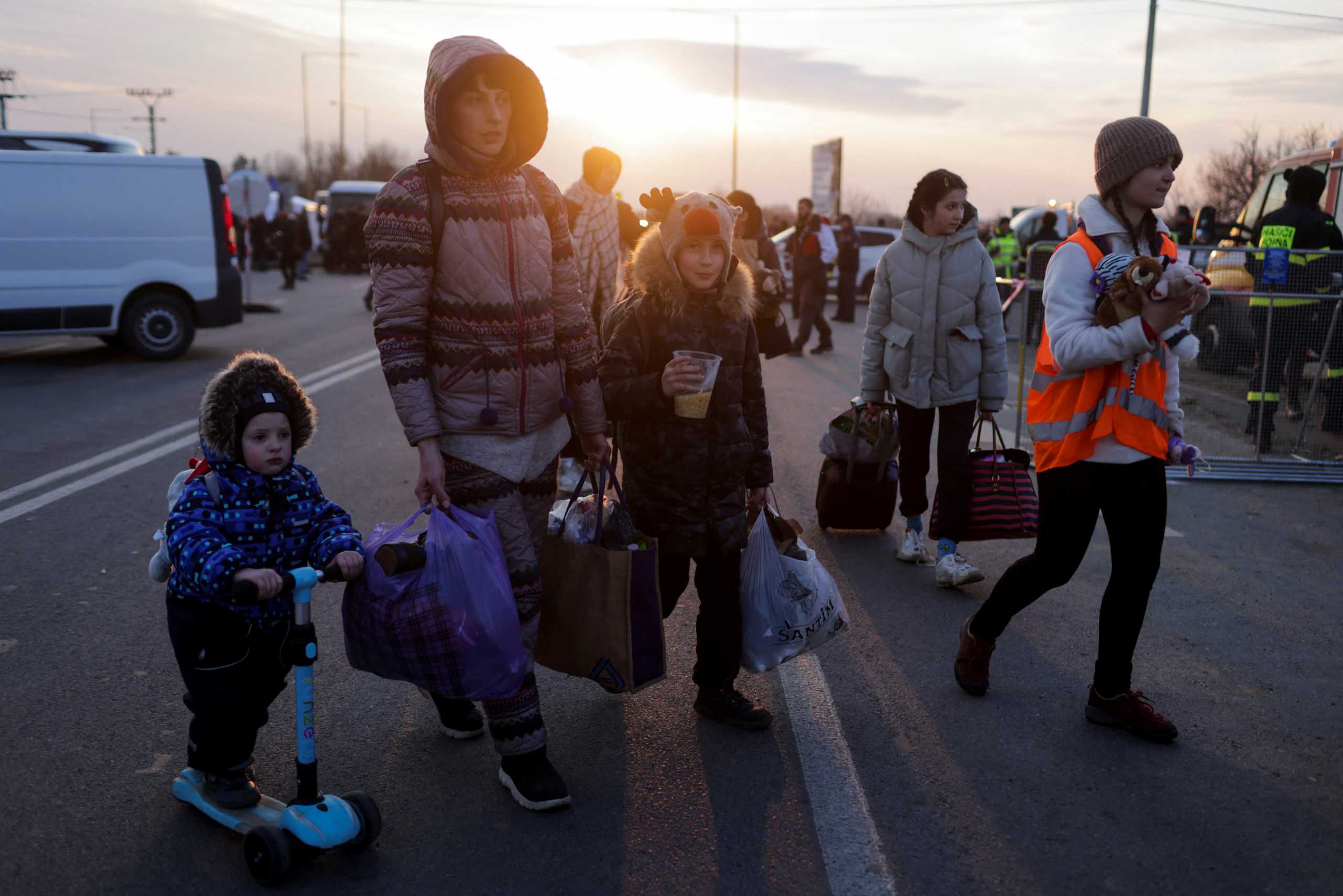 People carry luggage as refugees from Ukraine cross the Ukrainian-Slovakian border following Russia's invasion of Ukraine, in Vysne Nemecke, Slovakia, March 3, 2022. REUTERS