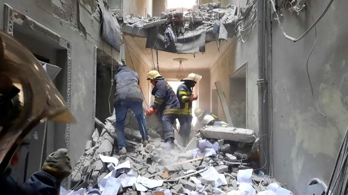 Rescuers are seen in a building, which city officials said was damaged by a missile, in central Kharkiv, Ukraine, in this handout picture released March 1, 2022. Press service of the Ukrainian State Emergency Service