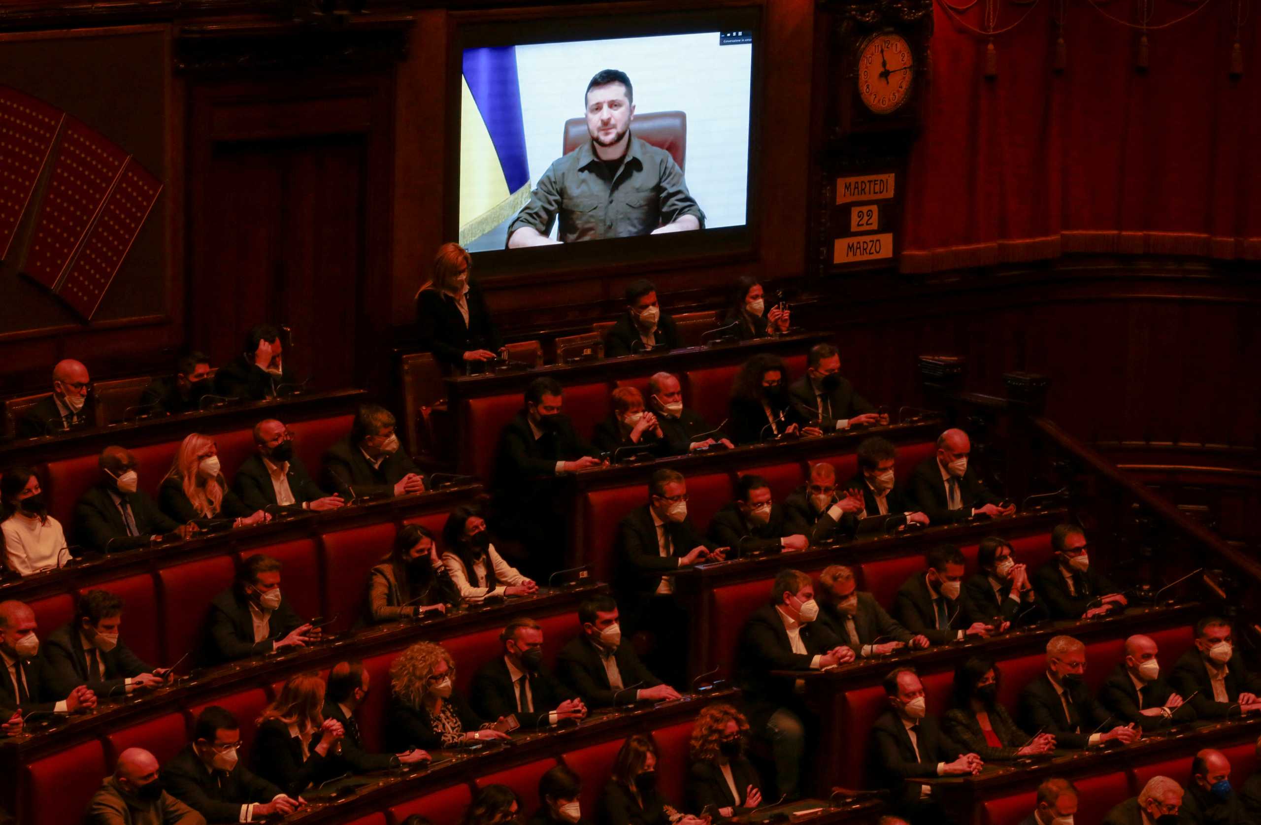 Ukrainian President Volodymyr Zelenskiy appears on a screen as he addresses the Italian parliament via videolink, amid Russia's invasion of Ukraine, in Rome, Italy, March 22, 2022. REUTERS
