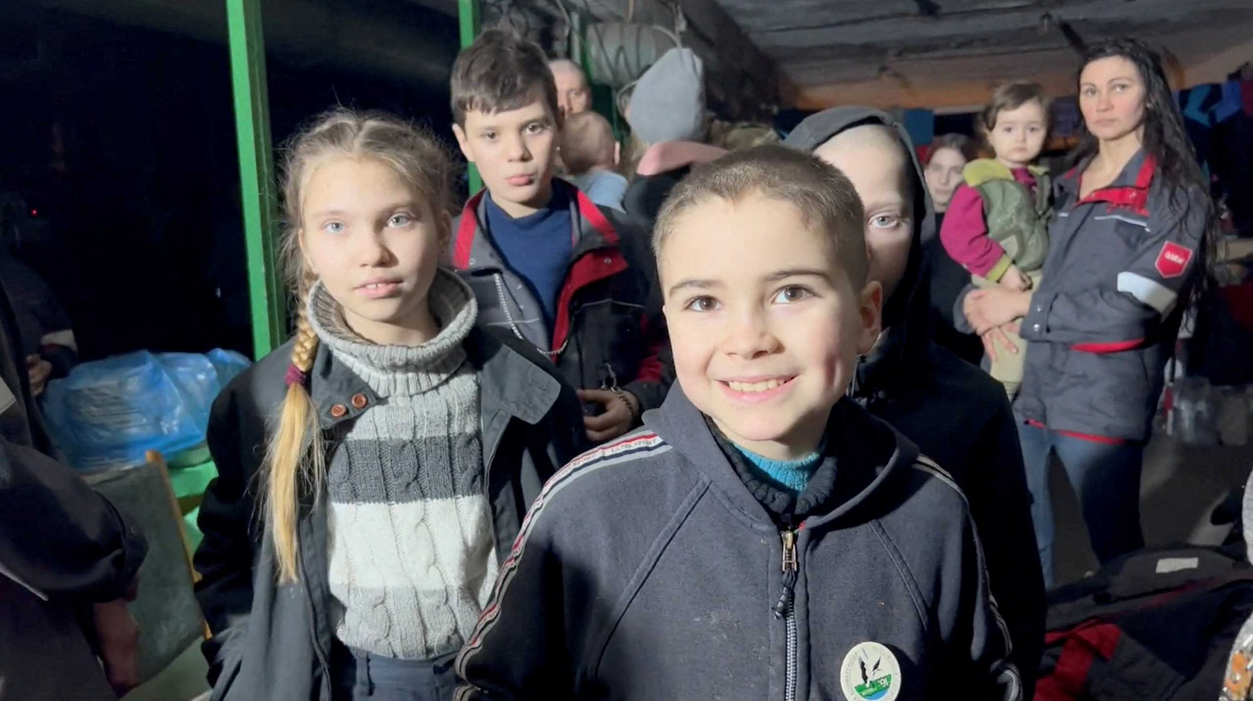 Children react as they take shelter, amid Russia's invasion of Ukraine, in a bunker said by Ukraine's Azov Battalion to be in Azovstal steelworks in Mariupol, Ukraine in this screen grab taken from a handout video obtained by Reuters on April 23, 2022. Azov Battalion