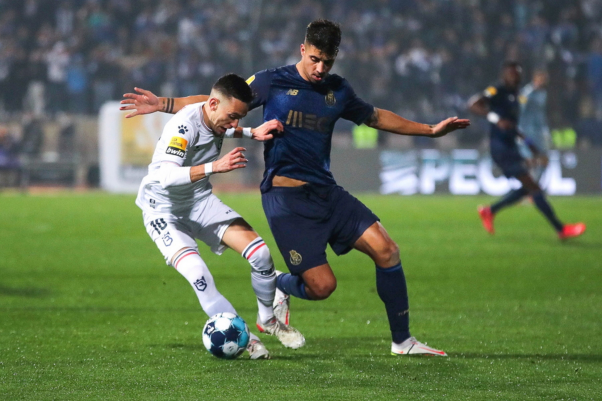 epa09690050 Afonso Sousa (L) of Belenenses in action against Fabio Cardoso (R) of FC Porto during the Portuguese First League soccer match between Belenenses SAD and FC Porto in Lisbon, Portugal, 16 January 2022.  EPA