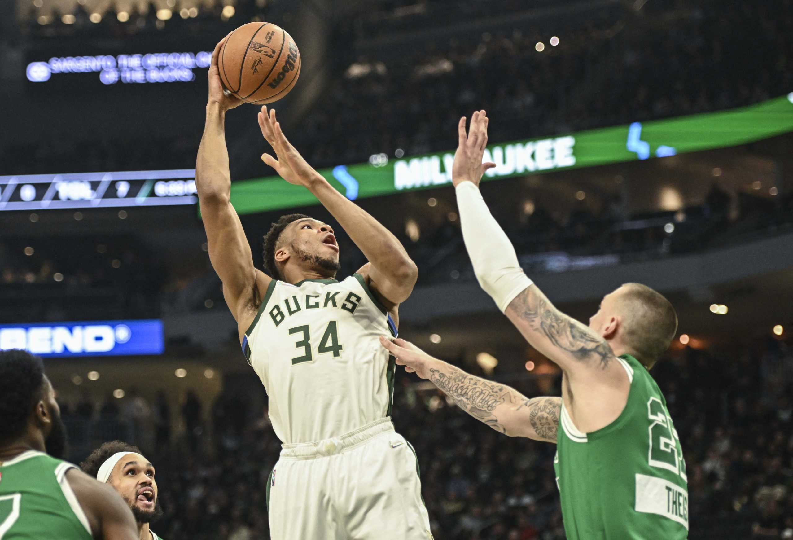Apr 7, 2022; Milwaukee, Wisconsin, USA;  Milwaukee Bucks forward Giannis Antetokounmpo (34) takes a shot against Boston Celtics center Daniel Theis (27) in the first quarter at Fiserv Forum. Mandatory Credit: Benny Sieu-USA TODAY Sports