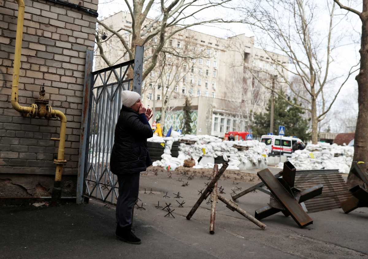 FILE PHOTO: A woman cries as she waits for news of her relative, in front of a destroyed Ukrainian government administration building following a bombing, as Russia's invasion of Ukraine continues, in Mykolaiv, Ukraine, March 29, 2022. REUTERS