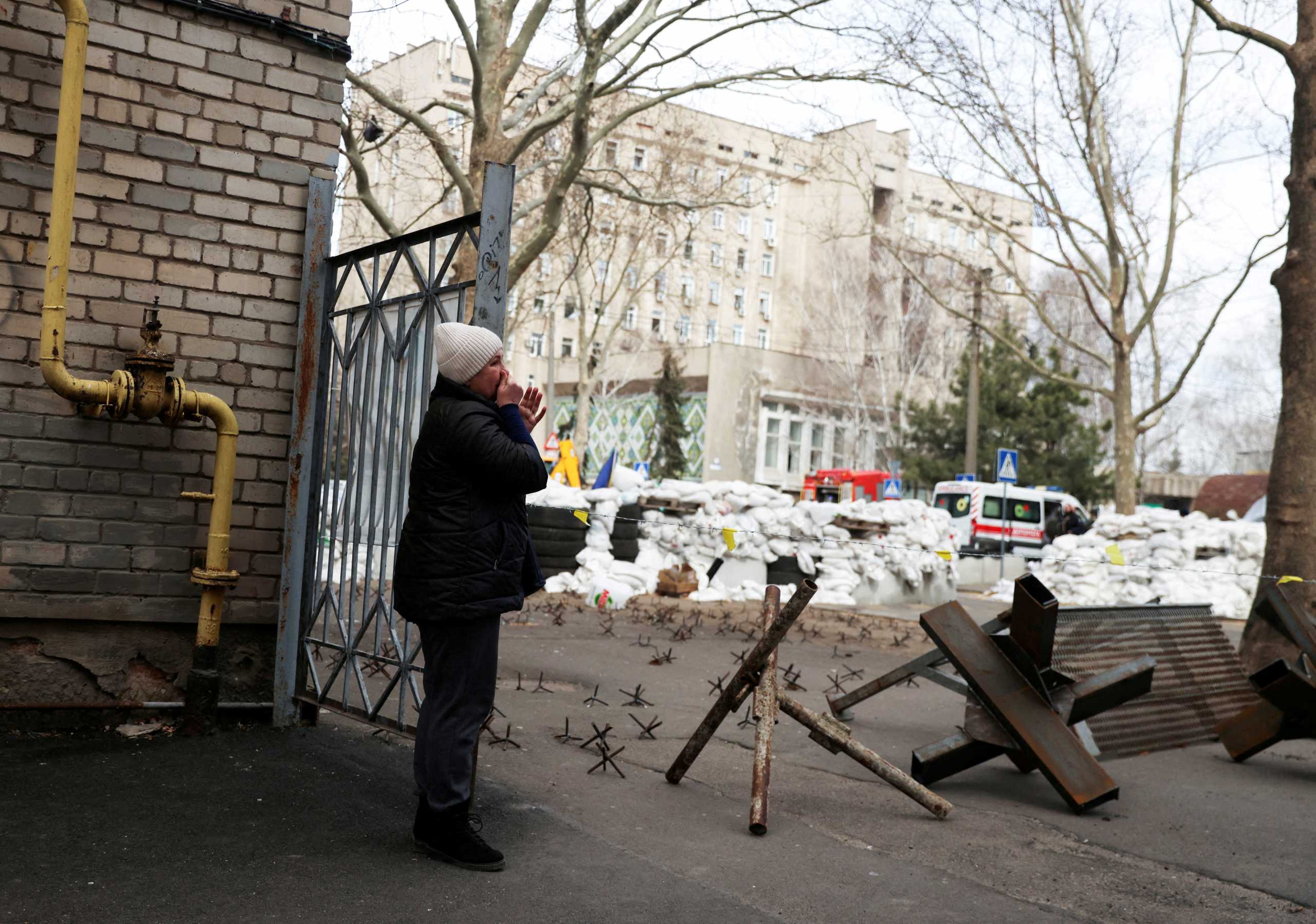 FILE PHOTO: A woman cries as she waits for news of her relative, in front of a destroyed Ukrainian government administration building following a bombing, as Russia's invasion of Ukraine continues, in Mykolaiv, Ukraine, March 29, 2022. REUTERS