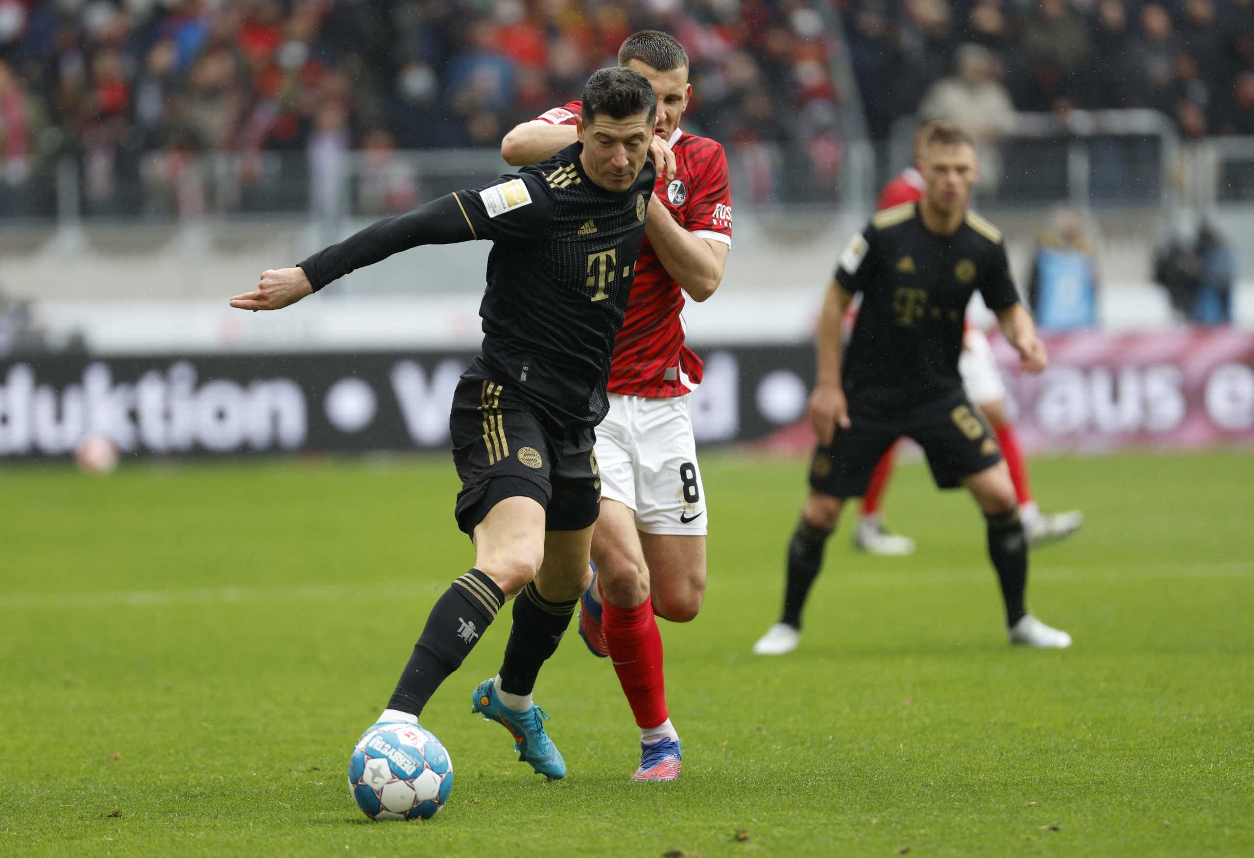 Soccer Football - Bundesliga - SC Freiburg v Bayern Munich - Europa Park Stadion, Freiburg, Germany - April 2, 2022  Bayern Munich's Robert Lewandowski in action with SC Freiburg's Maximilian Eggestein REUTERS