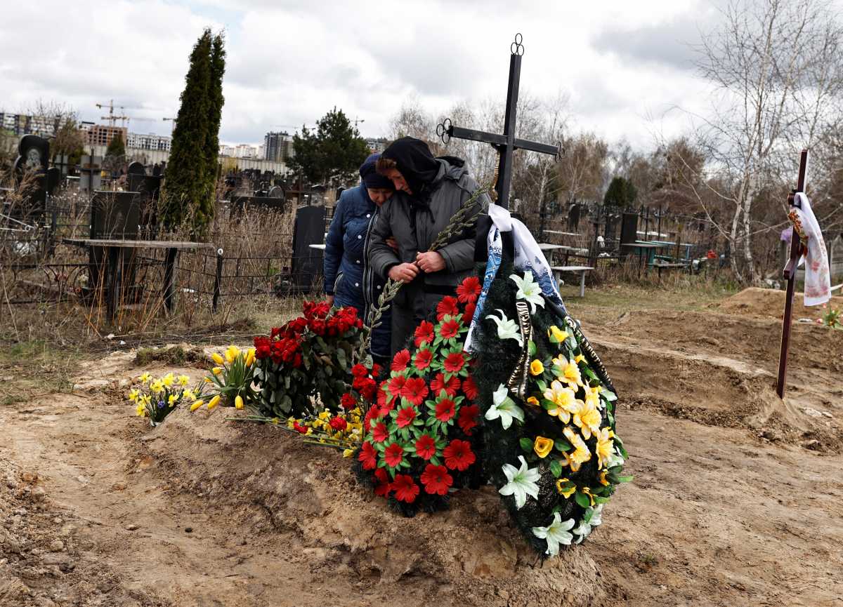 Galina Bondar (63), who said her son, Olexander Bondar (32), a territorial defence member, was killed by Russian troops, mourns by his grave at the cemetery in Bucha, amid Russia's invasion of Ukraine, Kyiv region, Ukraine April 17, 2022. REUTERS