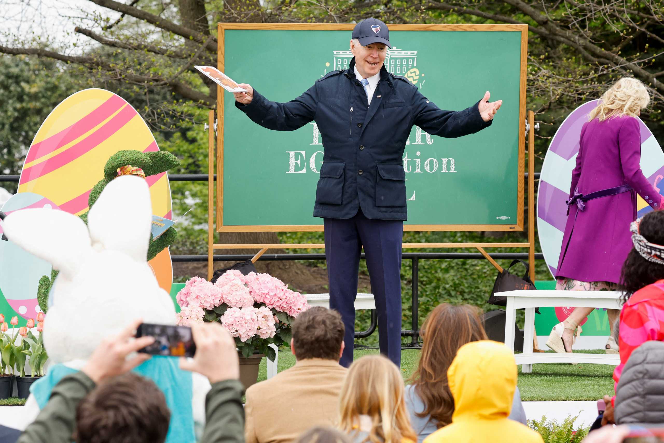 U.S. President Joe Biden does a reading of a book as first lady Jill Biden walks by on stage at the annual Easter Egg Roll on the South Lawn of the White House in Washington, U.S. April 18, 2022. REUTERS