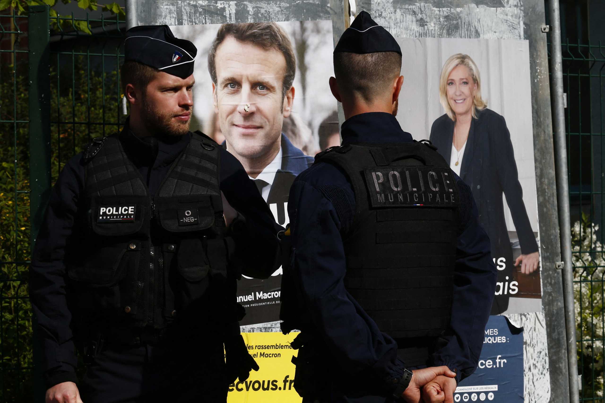 French police officers stand outside a polling station before the arrival of Marine Le Pen, French far-right National Rally (Rassemblement National) party candidate, to vote in the second round of the 2022 French presidential election, in Henin-Beaumont, France, April 24, 2022. REUTERS
