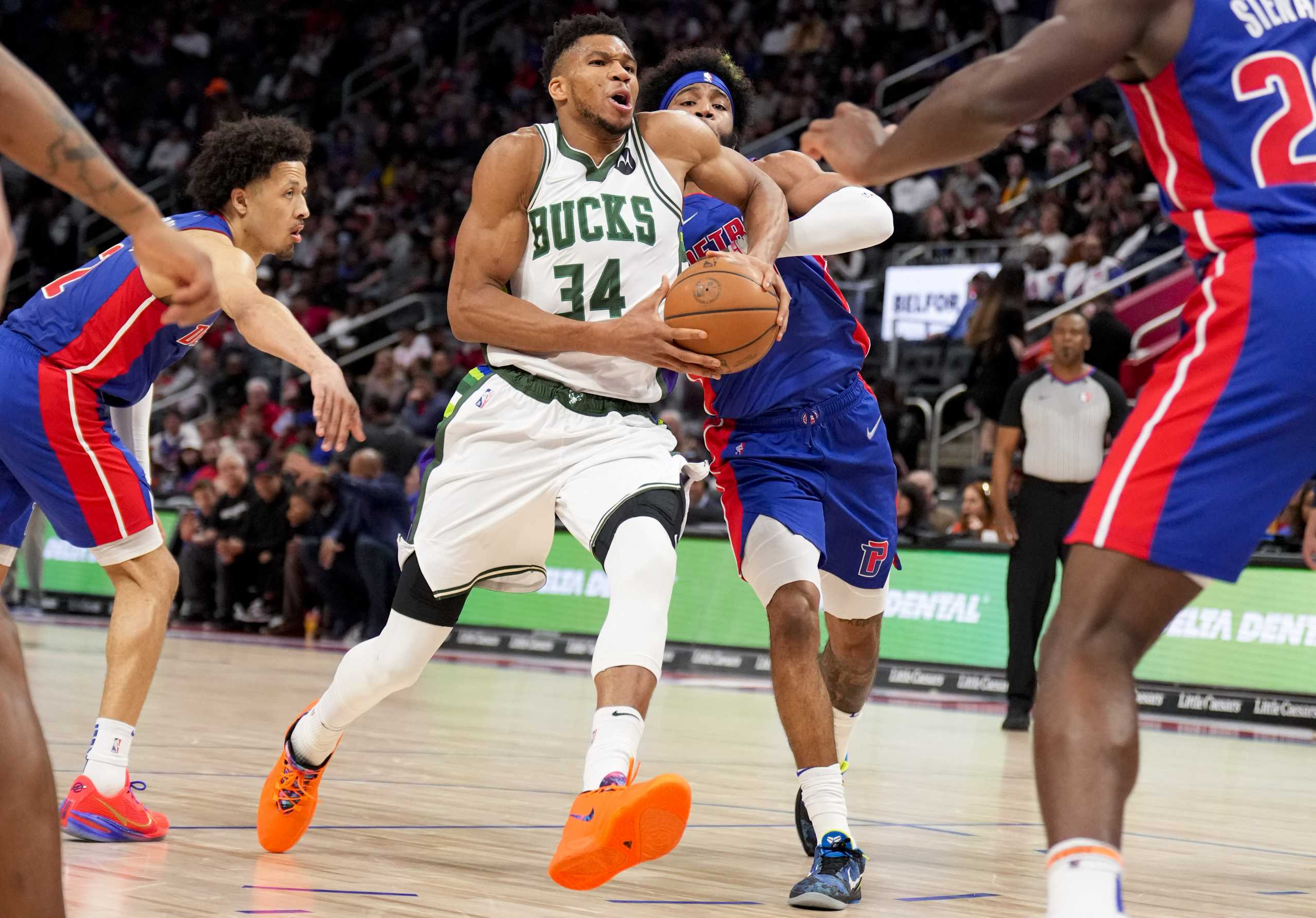 Apr 8, 2022; Detroit, Michigan, USA; Milwaukee Bucks forward Giannis Antetokounmpo (34) drives to the basket against Detroit Pistons forward Saddiq Bey (41) and guard Cade Cunningham (left) during the third quarter at Little Caesars Arena. Mandatory Credit: Raj Mehta-USA TODAY Sports