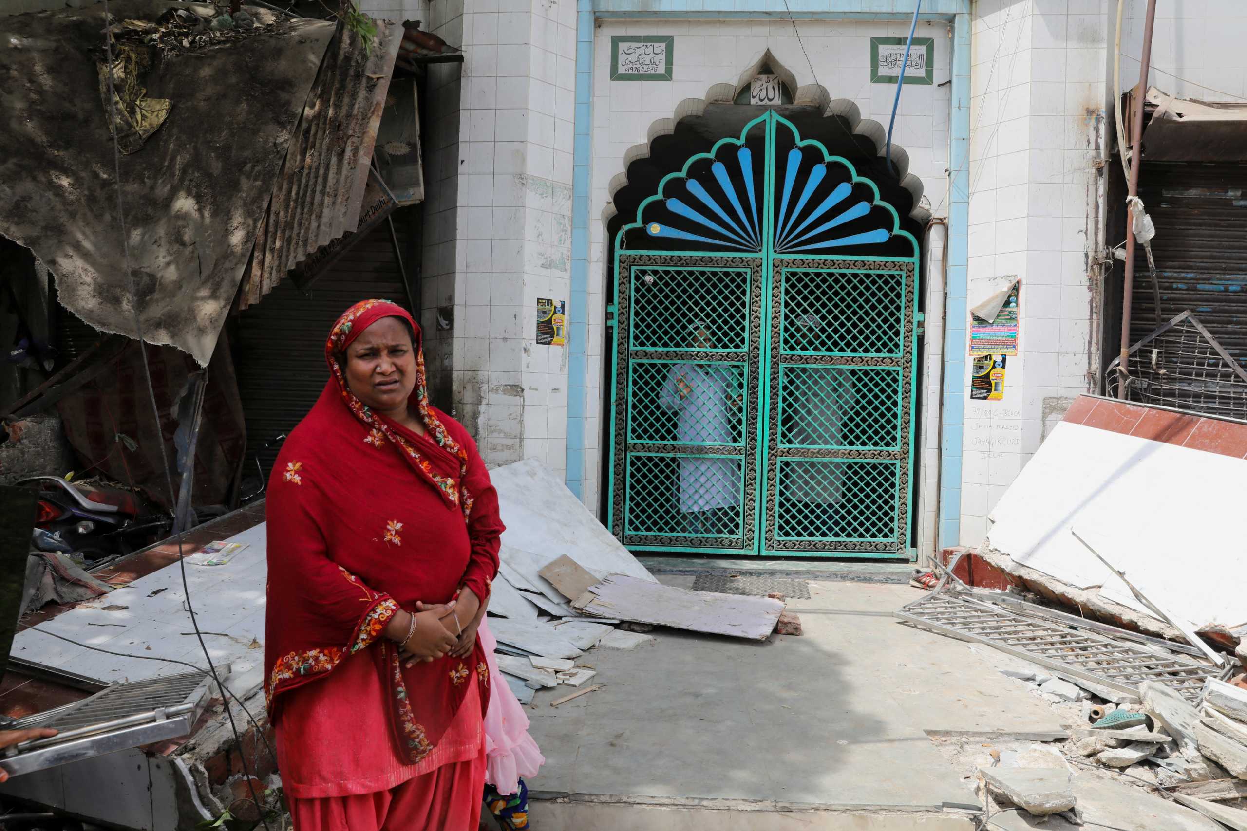 People from inside the mosque watch the demolition of small illegal retail shops in a communally sensitive area in Jahangirpuri, in New Delhi, India, April 20, 2022. REUTERS