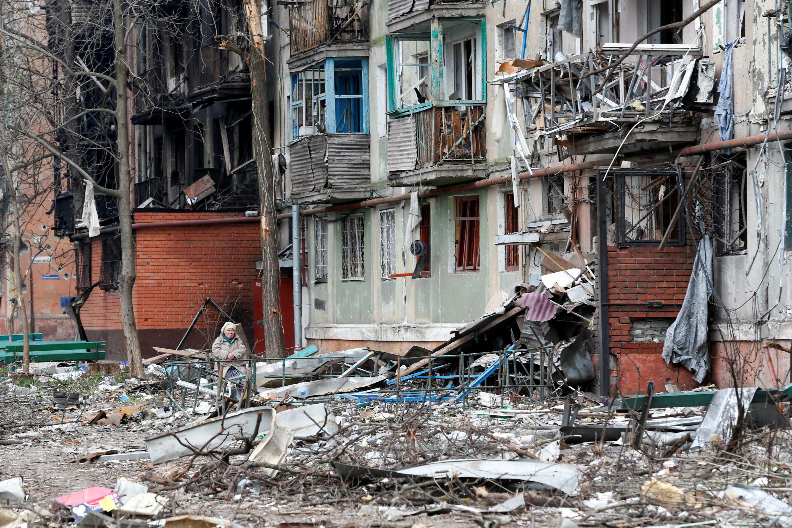 A local resident sits on a bench in a courtyard damaged during Ukraine-Russia conflict in the southern port city of Mariupol, Ukraine April 18, 2022. REUTERS