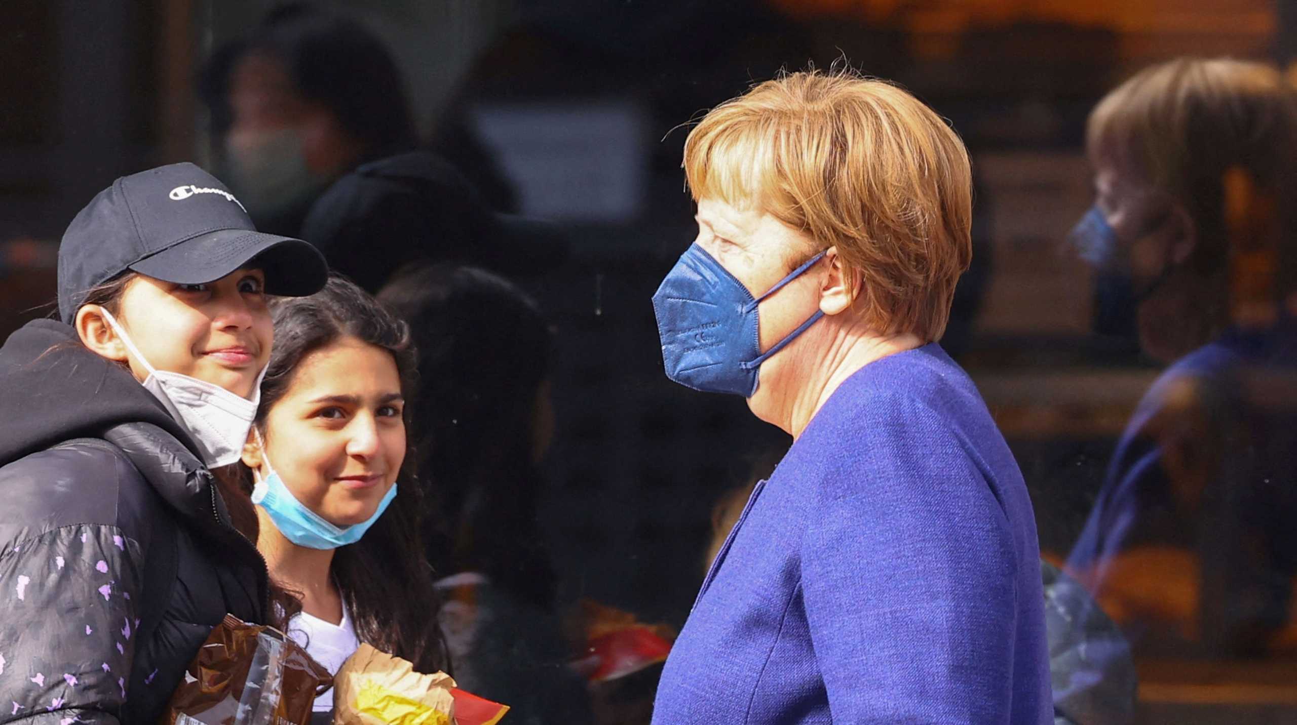 Pedestrians react when they spot former German Chancellor Angela Merkel walking on a public street after leaving a supermarket, in Berlin, Germany April 1, 2022.     REUTERS