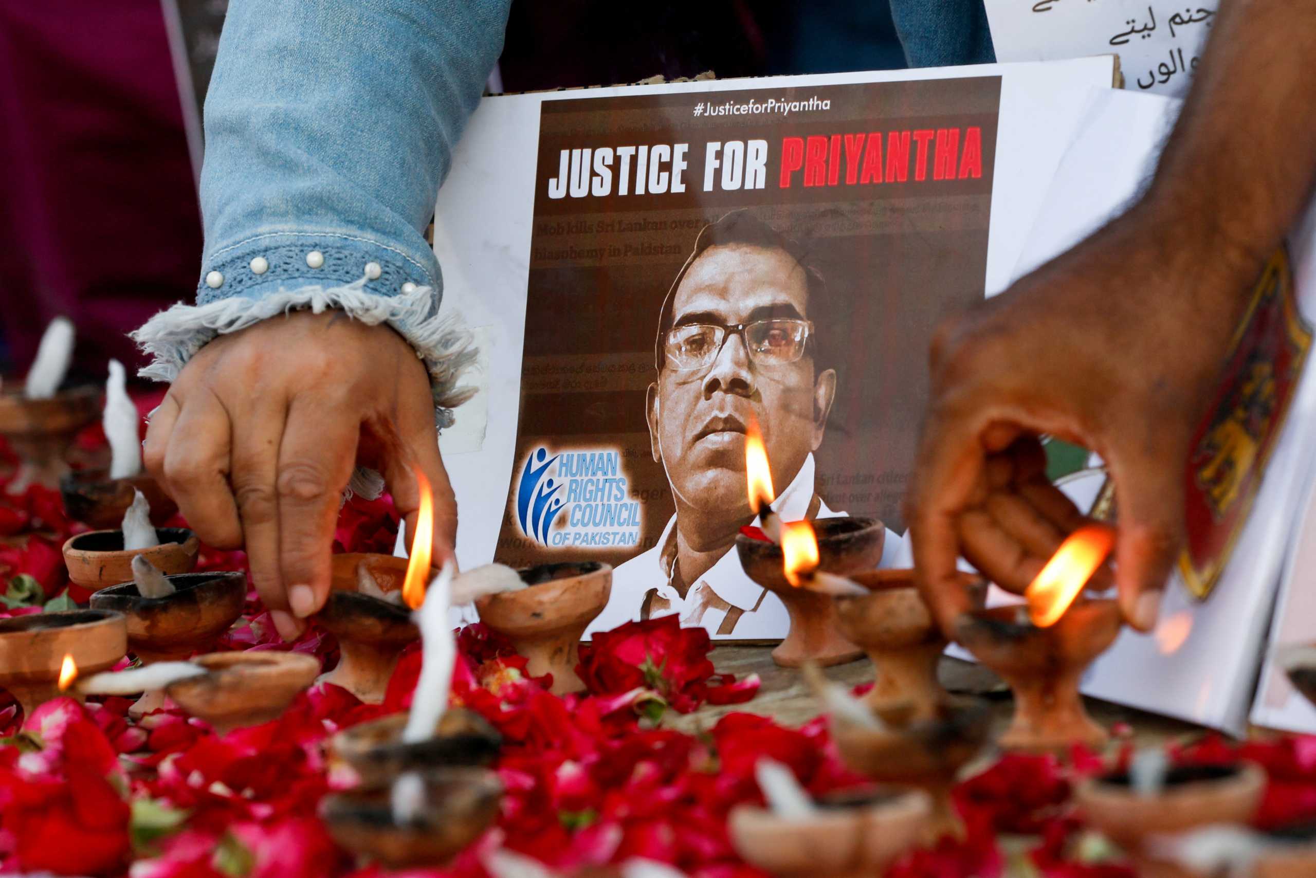 FILE PHOTO: People light oil lamps next to laid roses to express their condolences to the people of Sri Lanka, following the lynching of the Sri Lankan manager of a garment factory after an attack on the factory in Sialkot, in Karachi, Pakistan December 5, 2021. REUTERS