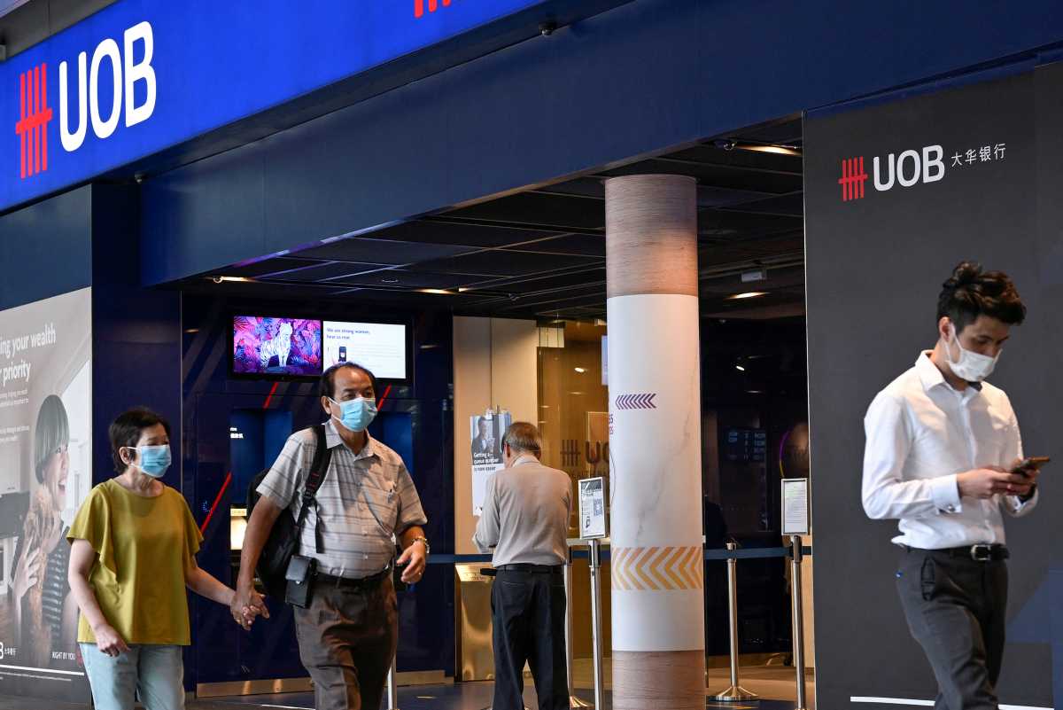People walk past a United Overseas Bank branch in Singapore March 31, 2022. REUTERS