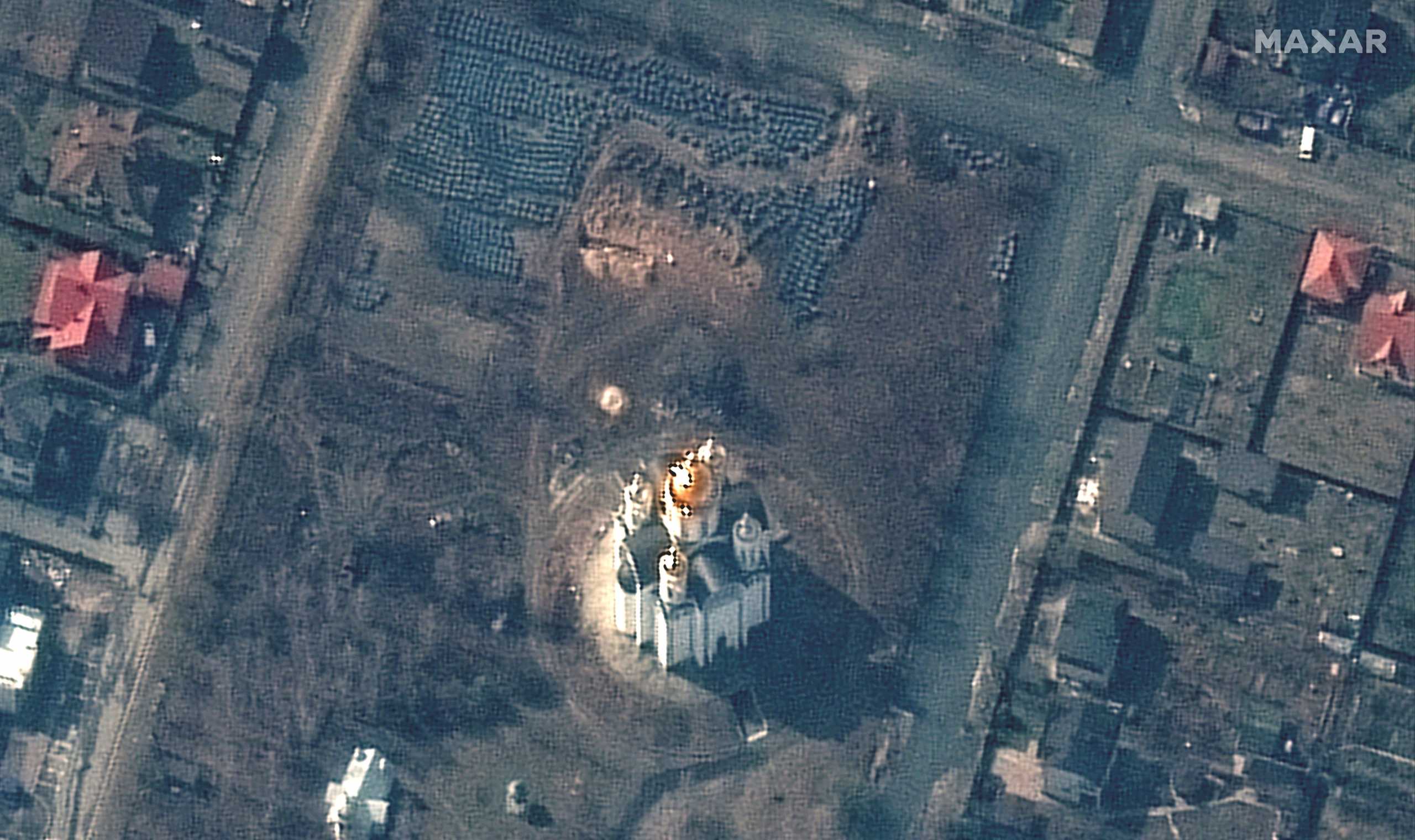 A satellite image shows the grave site with an approximately 45-foot (approximately 13,7 meters) long trench in the southwestern section of the area near the Church of St. Andrew and Pyervozvannoho All Saints, in Bucha, Ukraine, March 31, 2022. Picture taken March 31, 2022. Satellite image 2022 Maxar Technologies