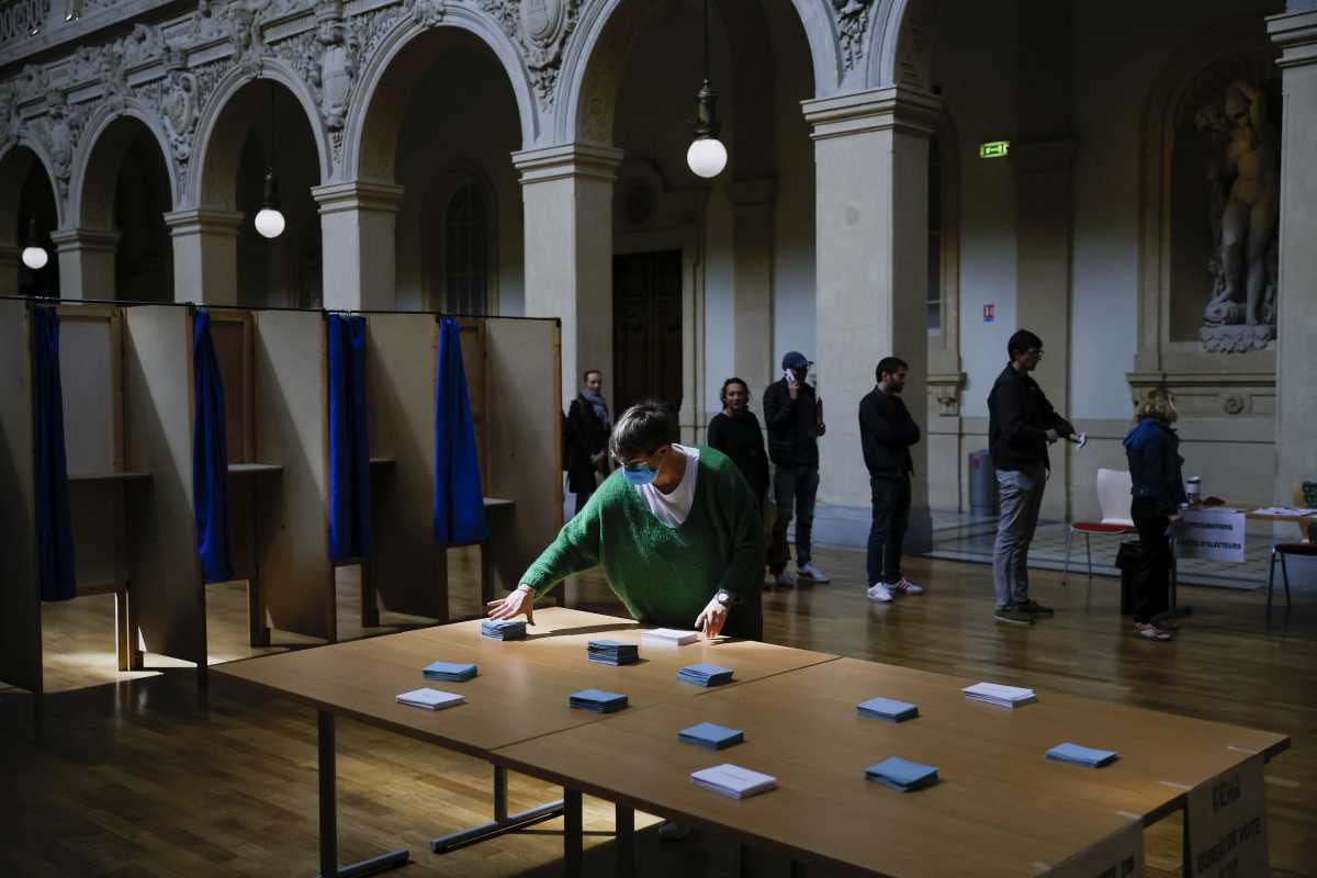 People queue to vote in the second round of the 2022 French presidential election at a polling station in Lyon, France, April 24, 2022. REUTERS