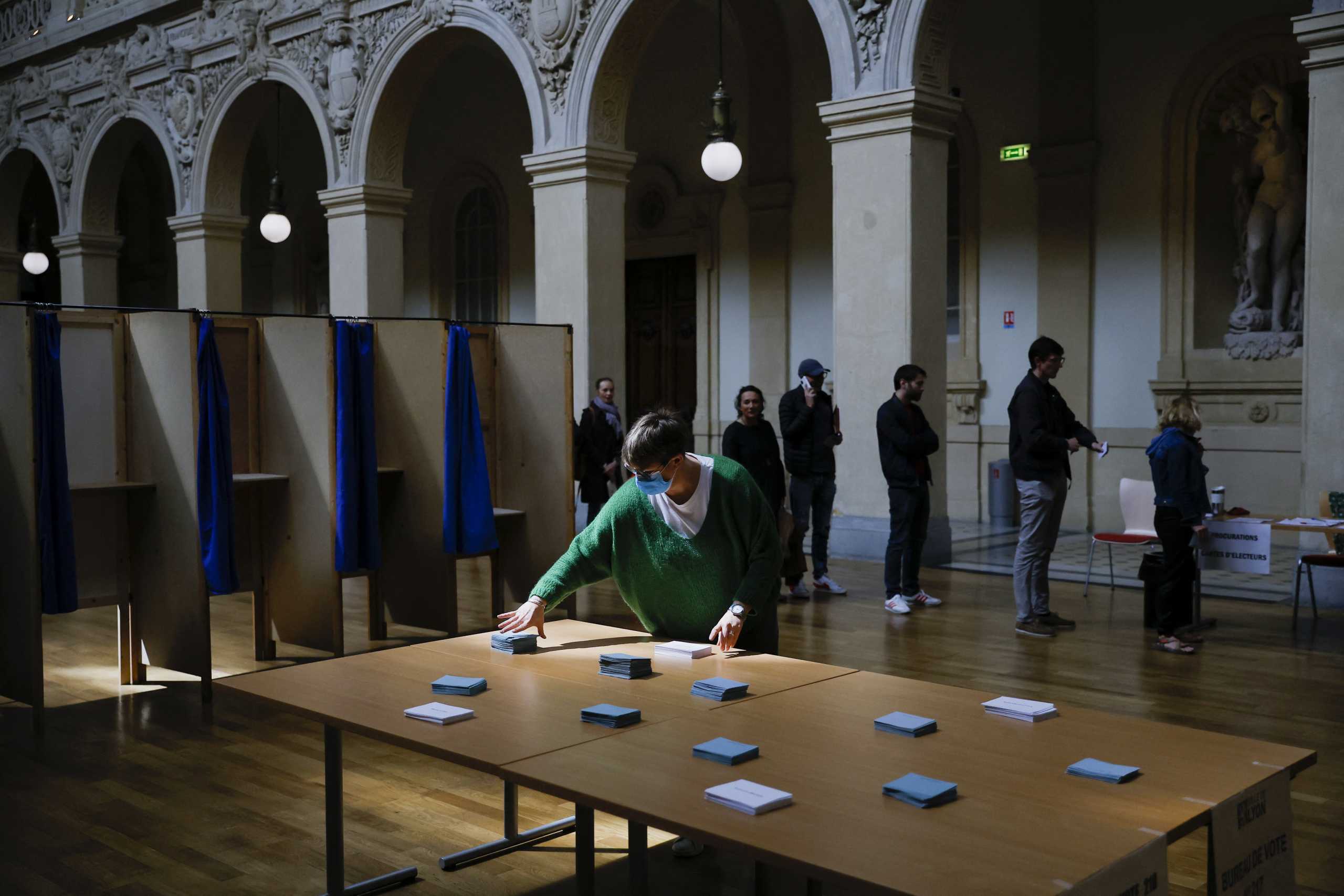People queue to vote in the second round of the 2022 French presidential election at a polling station in Lyon, France, April 24, 2022. REUTERS