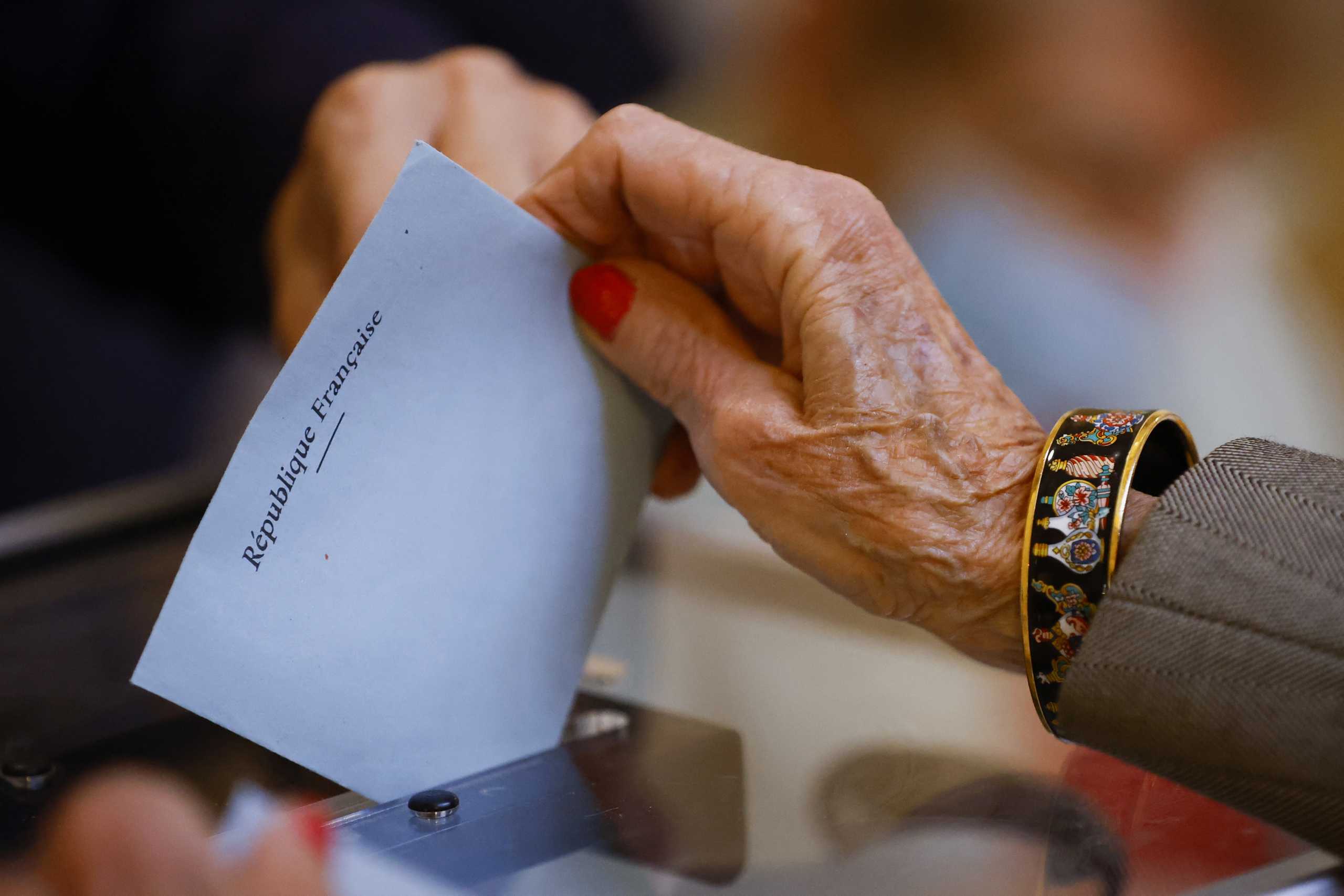A woman casts her ballot in the second round of the 2022 French presidential election at a polling station in Lyon, France, April 24, 2022. REUTERS