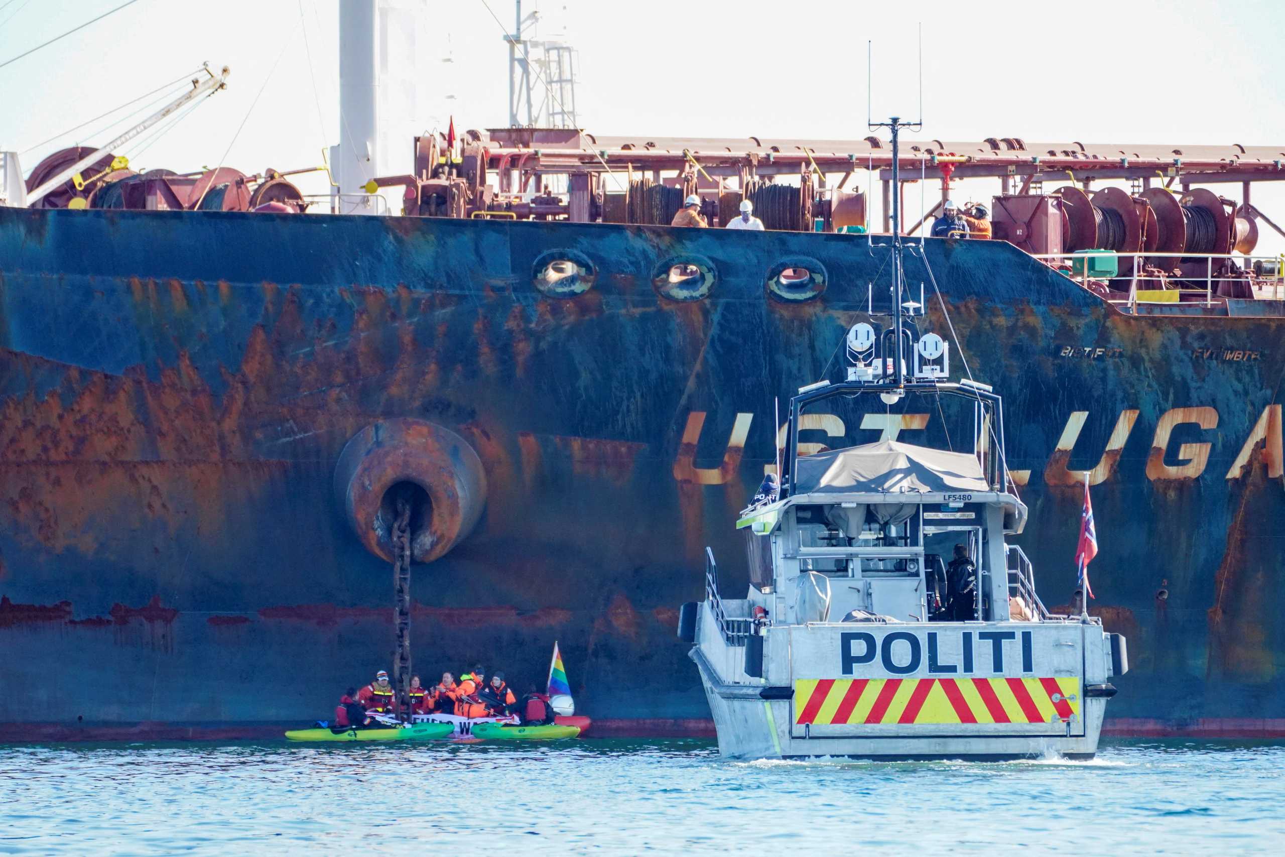 A police vessel sails near members of Greenpeace blocking a tanker "Ust Luga" from delivering Russian oil to Norway as part of a protest against the Russia's invasion of Ukraine, according to Greenpeace, near Asgardstrand, Norway April 25, 2022.  Ole Berg-Rusten