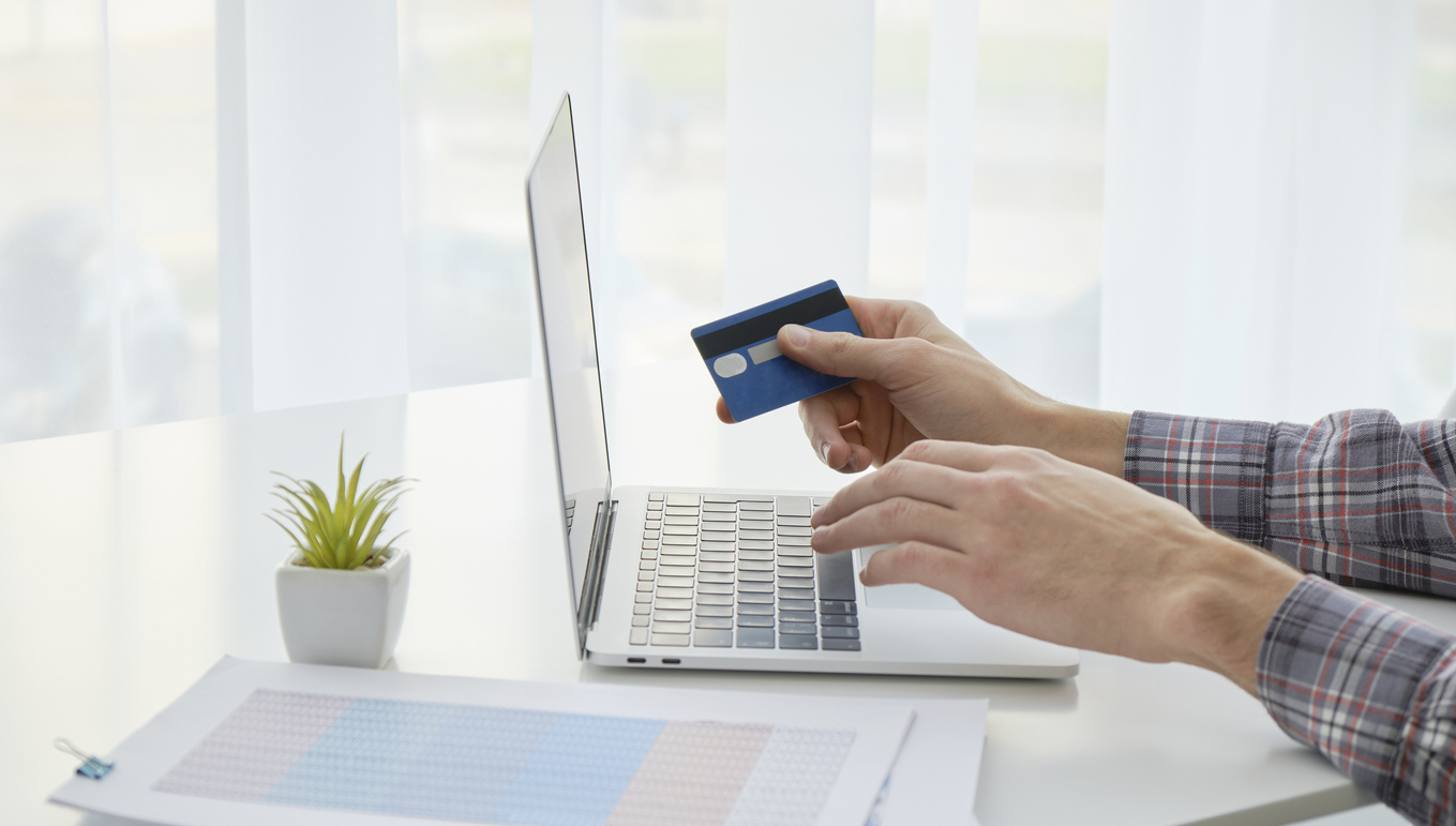 Hands holding credit card and using laptop. Online shopping