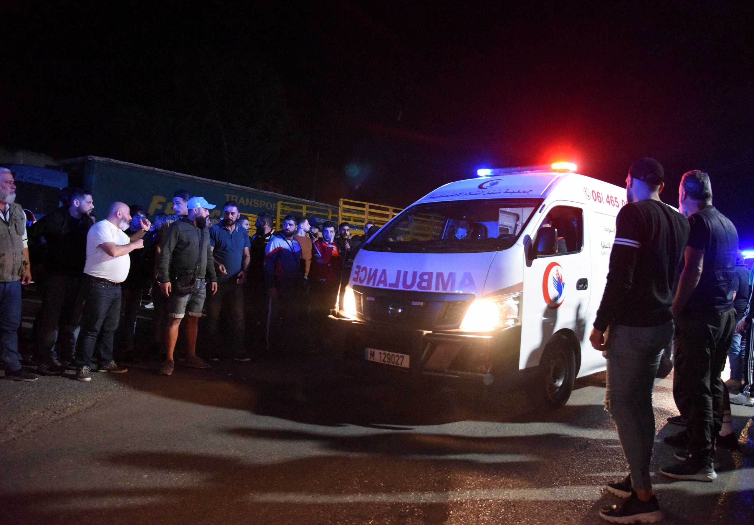People gather as an ambulance drives following the sinking of a boat off the coast of Lebanon's northern port city of Tripoli, outside the port of Tripoli, Lebanon April 23, 2022. Picture taken April 23, 2022. REUTERS