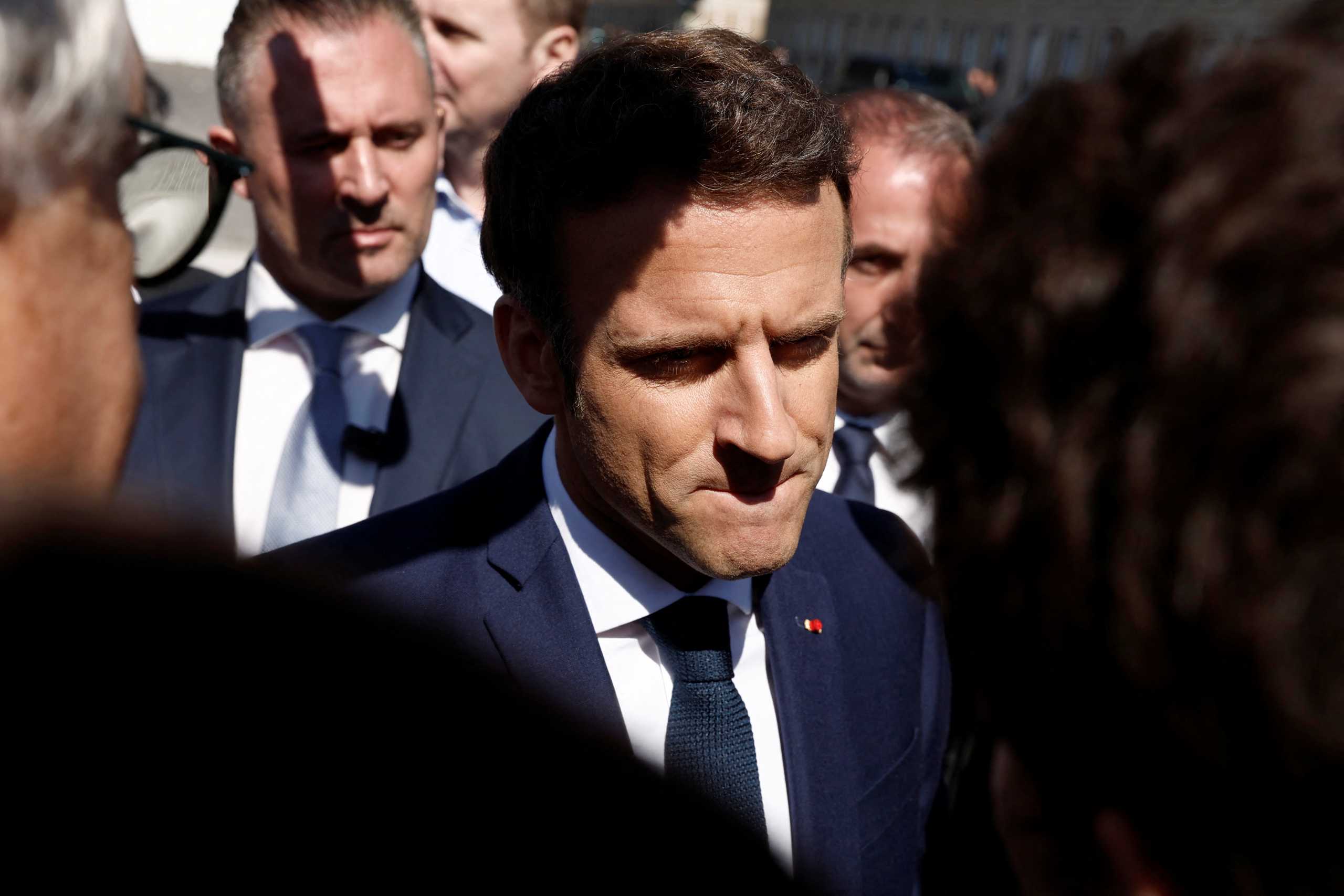 French President Emmanuel Macron, candidate for his re-election in the 2022 French presidential election, reacts as he meets with residents during a campaign trip in Le Havre, France, April 14, 2022.  REUTERS