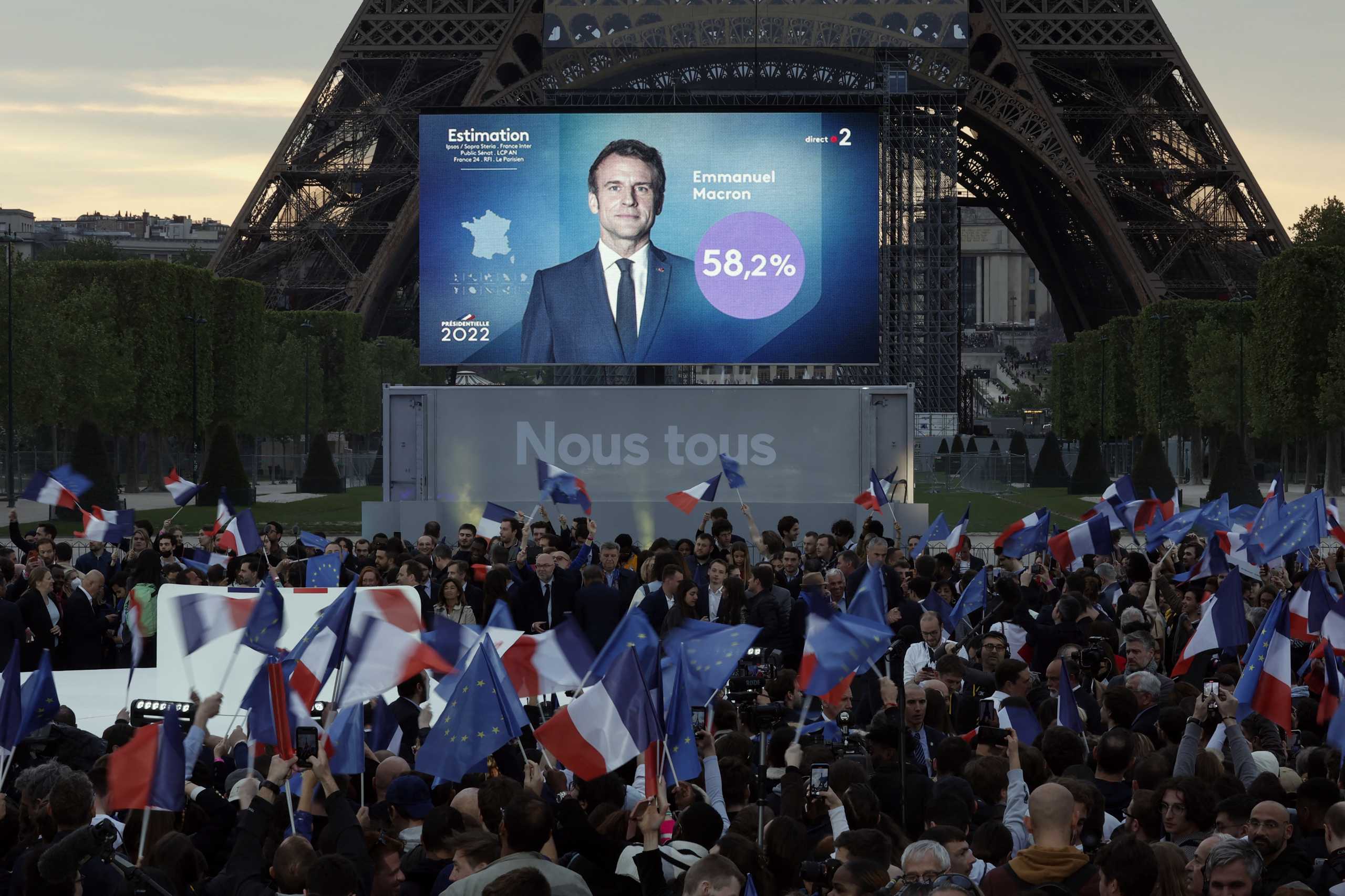 Supporters of French President Emmanuel Macron,  candidate for his re-election,  react after results were announced in the second round vote of the 2022 French presidential election, near Eiffel Tower, at the Champs de Mars in Paris, France April 24, 2022. REUTERS
